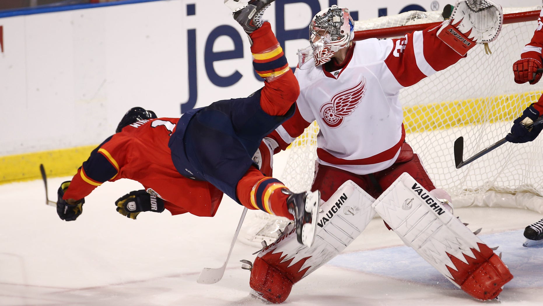 After hitting Detroit Red Wings goalie Jimmy Howard's (35) stick, Florida Panthers' Jesse Winchester falls to the ice during the third period of a NHL hockey game in Sunrise, Fla., Tuesday, Dec. 10, 2013. The Panthers won 3-2 in a shootout during overtime. (AP Photo/J Pat Carter)