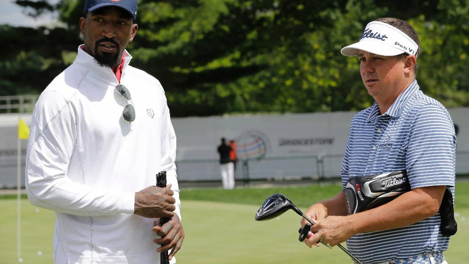 Cleveland Cavaliers' J.R. Smith, left, talks with Jason Dufner during the practice round of the Bridgestone Invitational golf tournament at Firestone Country Club, Wednesday, June 29, 2016, in Akron, Ohio. (AP Photo/Tony Dejak)