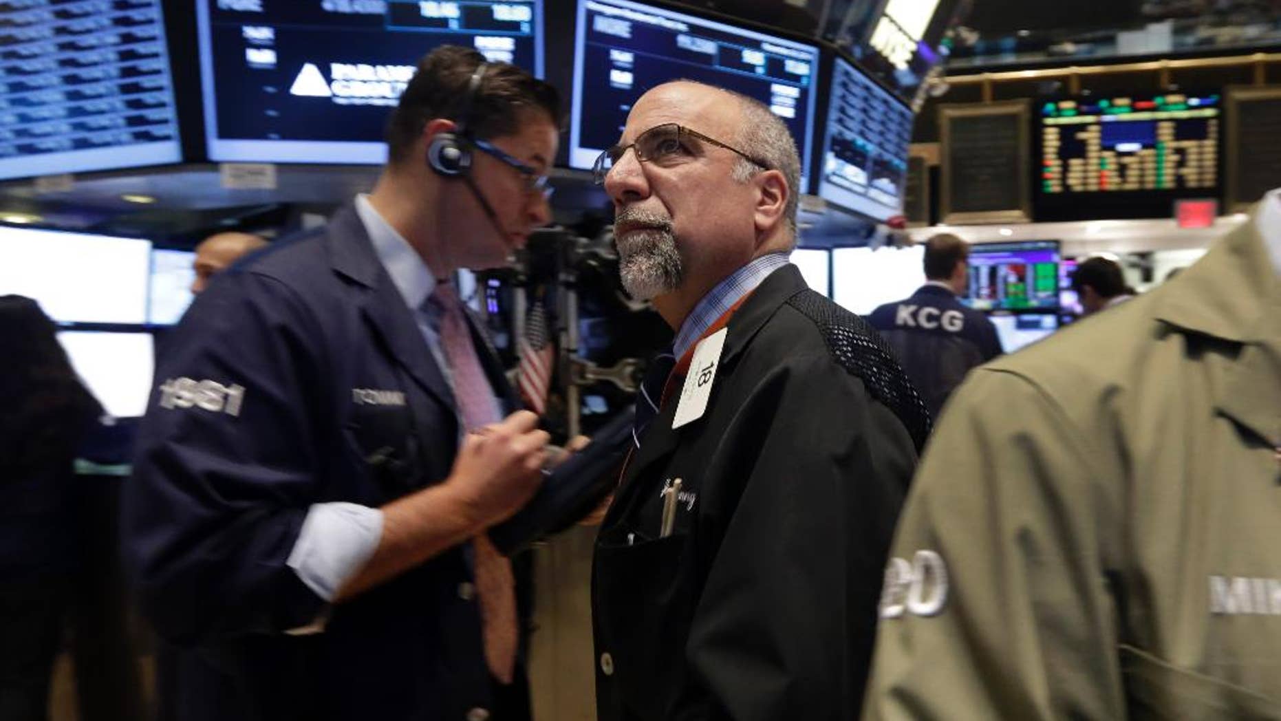 In this Monday, Nov. 24, 2014 photo, trader John Lotito, center, works on the floor of the New York Stock Exchange. U.S. stocks rose in early trading Tuesday, Nov. 25, after the government revised up its estimate for economic growth in the third quarter, giving the U.S. its strongest six months of growth in a decade. Stocks are trading at all-time highs. (AP Photo/Richard Drew)