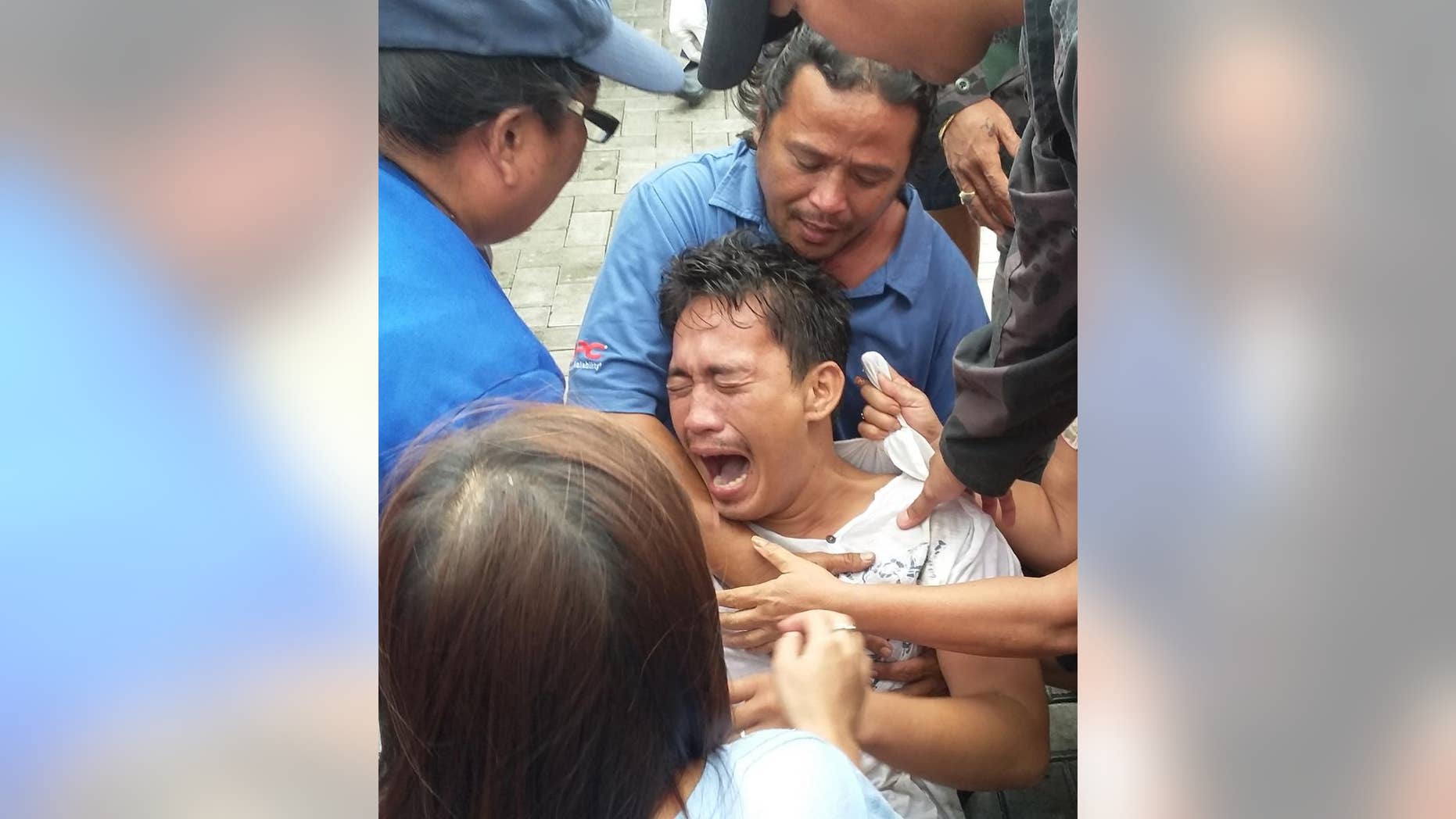 Police and rescuers comfort a crying passenger after being brought to the pier upon his rescue from a sinking passenger ferry Thursday, July 2, 2015 in Ormoc city, central Philippines. Coast Guard officials say the boat capsized minutes after it left a central Philippine port in choppy waters, leaving at least 36 dead and 26 others missing. They said at least 127 people from the M/B Kim Nirvana were rescued by nearby fishing boats and coast guard personnel or swam to safety off Ormoc city on Leyte Island. (AP Photo/John Pilapil)