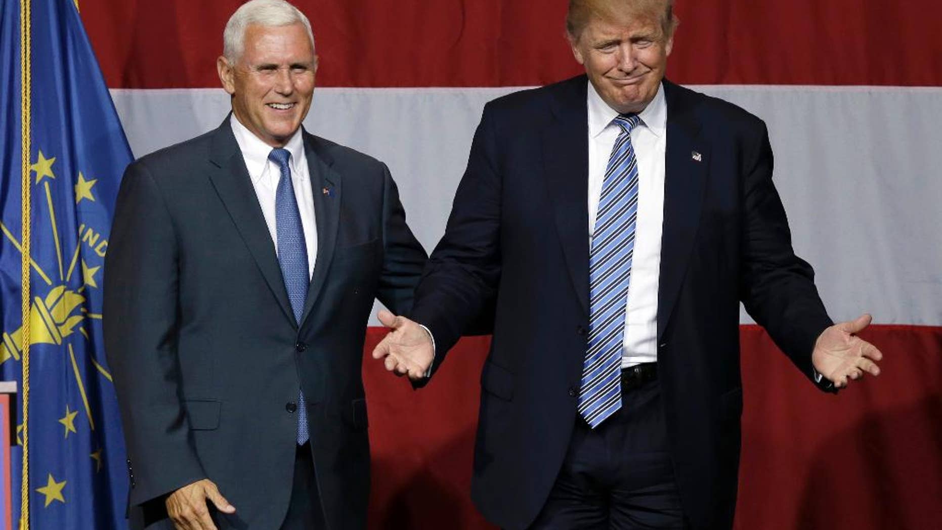 FILE - In this July 12, 2016 file photo, Indiana Gov. Mike Pence joins Republican presidential candidate Donald Trump at a rally in Westfield, Ind. Over the past two decades, Trump has disagreed with his vice-presidential pick on plenty of political issues, including immigration policy, entitlement programs and trade. On social issues above all, Trump and Pence arrive at the 2016 general election from very different paths. (AP Photo/Michael Conroy, File)