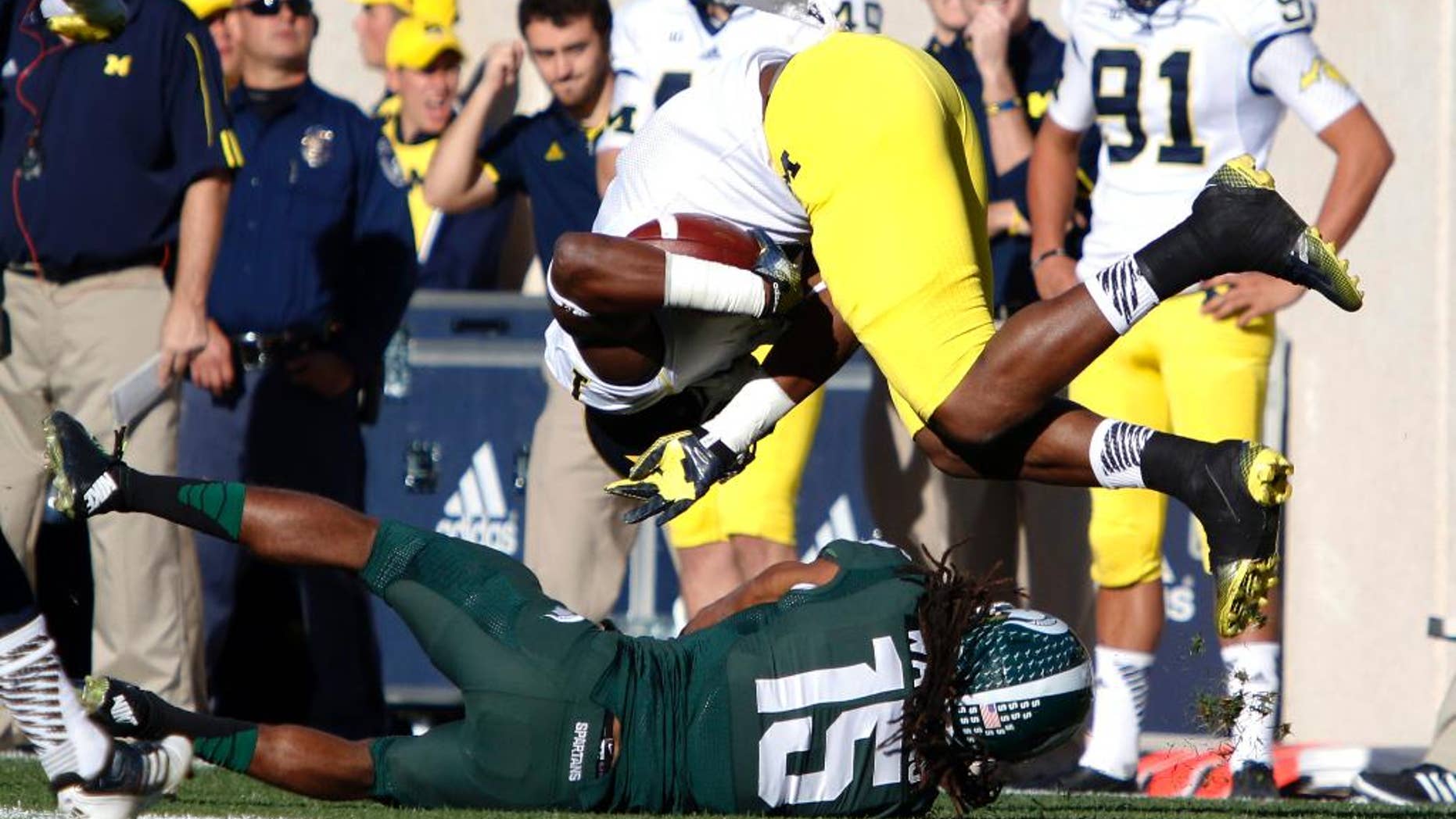 Michigan receiver Devin Funchess, top, is upended by Michigan State's Trae Waynes during the second quarter of an NCAA college football game, Saturday, Oct. 25, 2014, in East Lansing, Mich. (AP Photo/Al Goldis)