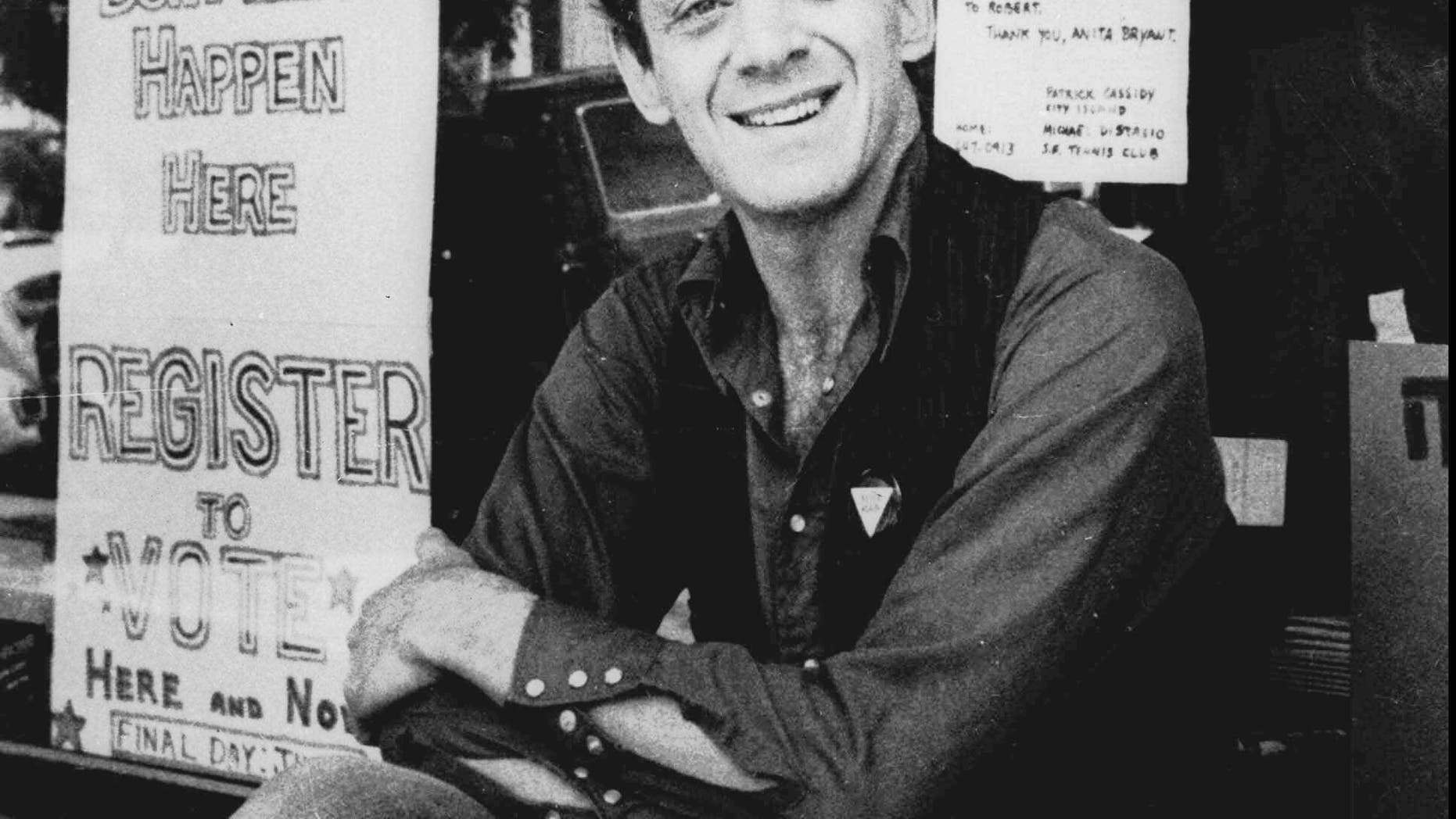 FILE: Harvey Milk poses in front of his camera shop in San Francisco.