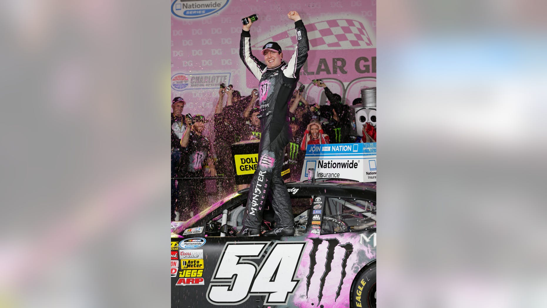 Kyle Busch celebrates in victory lane after winning the NASCAR Nationwide series auto race at Charlotte Motor Speedway in Concord, N.C., Friday, Oct. 11, 2013. (AP Photo/Chuck Burton)