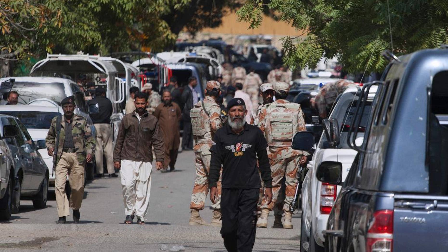Pakistani paramilitary soldiers and police commandos gather outside the Afghan consulate after the shooting.