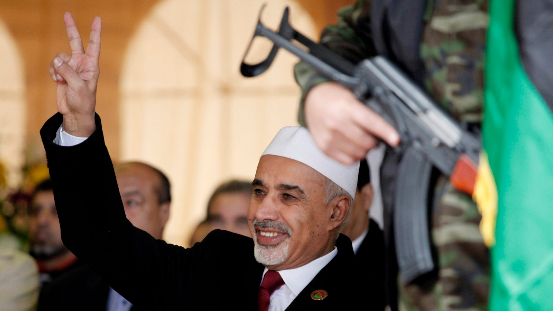 FILE - In this Sunday, Feb. 17, 2013 file photo, Libyan interim president, Mohammed el-Megarif flashes the victory sign to the crowd during the celebration of the second anniversary of the Libyan revolution in Benghazi, Libya. The head of Libya’s elected parliament has announced his resignation on Tuesday, May 28, 2013, just weeks after the body he led passed a law that bans officials who served under ousted dictator Moammar Gadhafi from senior government posts. Al-Megarif, who was Libya’s ambassador to India in 1980 before he joined the opposition in exile, teared up as he wished his country well and announced he is stepping down. (AP Photo/Mohammad Hannon, File)