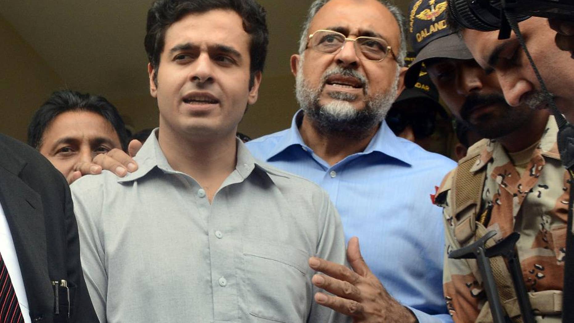 Awais Shah, center left, speaks to journalists with his father Sajjad Ali Shah, center right, chief justice of Sindh's High Court, after the son was rescued from kidnappers.