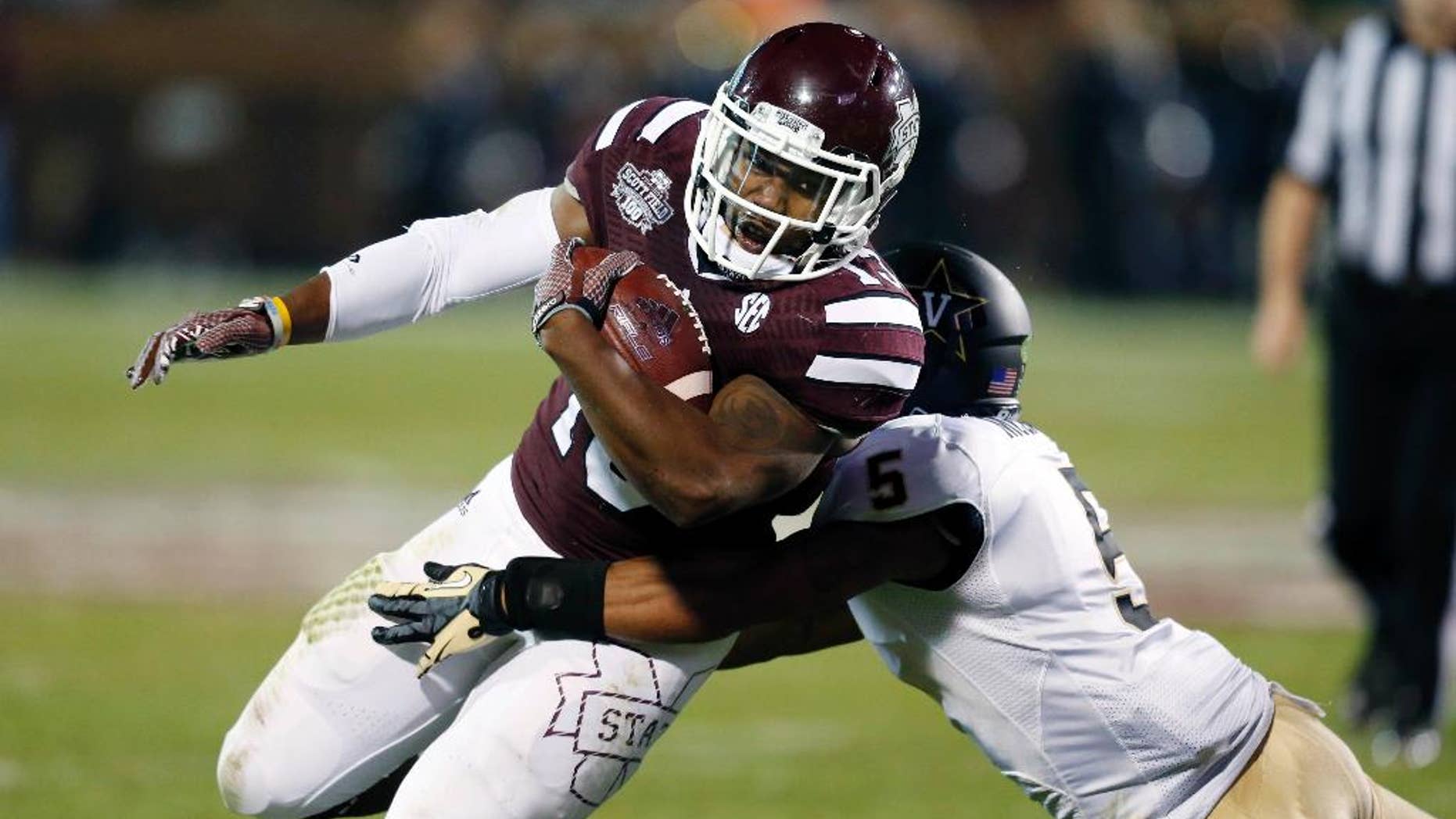 Mississippi State running back Josh Robinson (13) is tackled by Vanderbilt defensive back Torren McGaster (5) after a run for a first down in the first half of an NCAA college football game Saturday, Nov. 22, 2014, in Starkville, Miss. (AP Photo/Rogelio V. Solis)