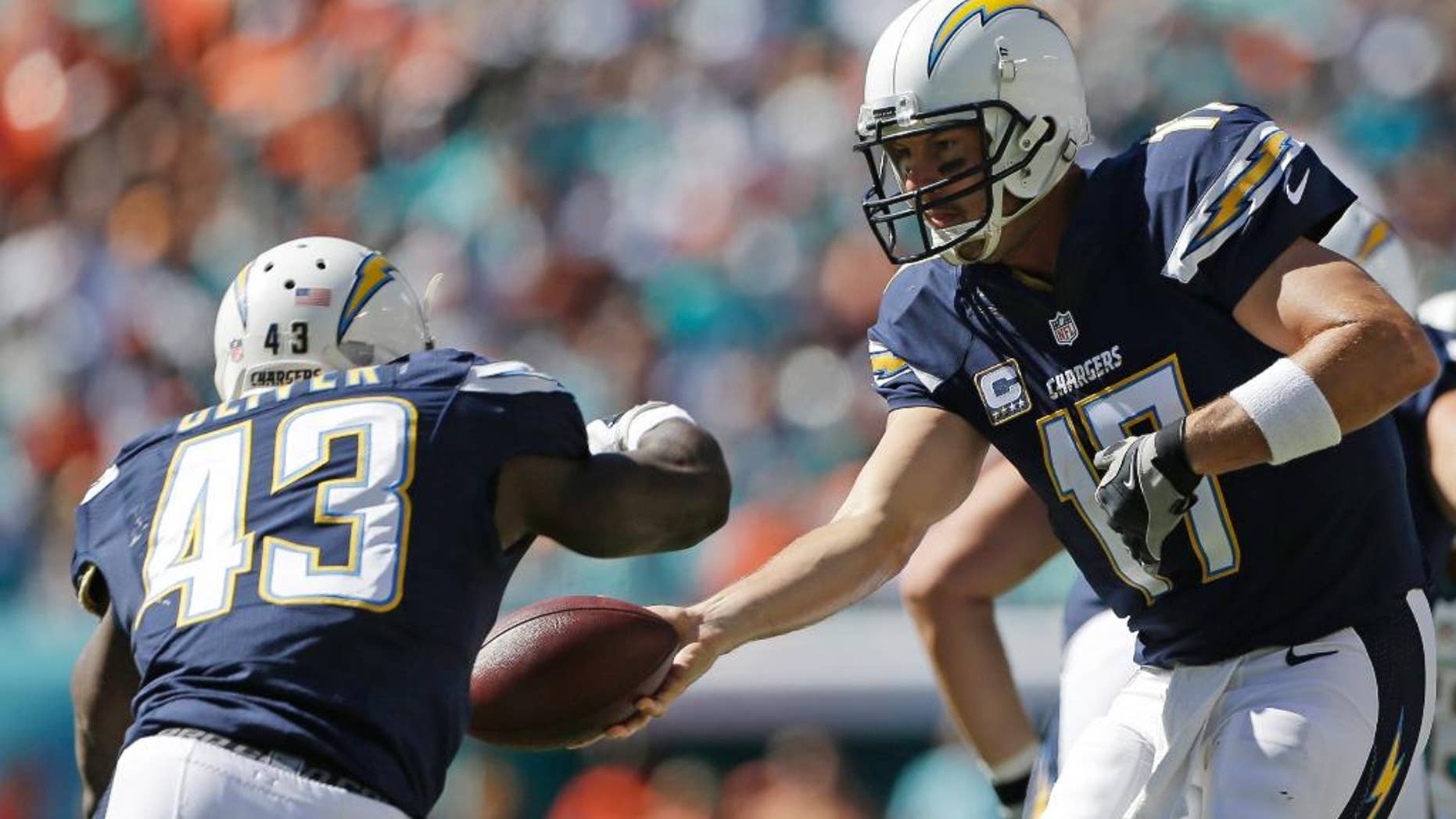 San Diego Chargers quarterback Philip Rivers (17) hands the ball to running back Branden Oliver (43 ) during the first half of an NFL football game against the Miami Dolphins, Sunday, Nov. 2, 2014, in Miami Gardens, Fla. (AP Photo/Alan Diaz)