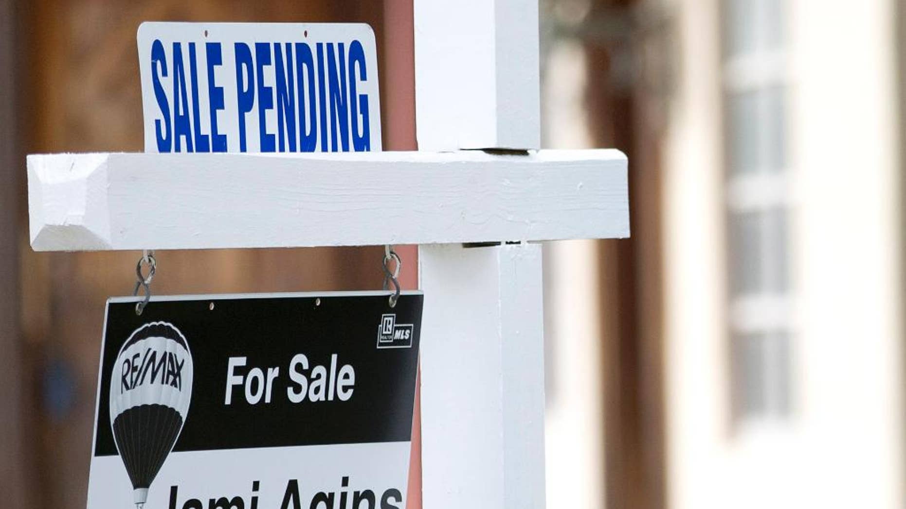 FILE - In this Thursday, Jan. 8, 2015, file photo, a "sale pending" sits atop a realty sign outside a home for sale in Surfside, Fla. The National Association of Realtors releases its pending home sales index for June on Wednesday, July 29, 2015. (AP Photo/Wilfredo Lee, File)