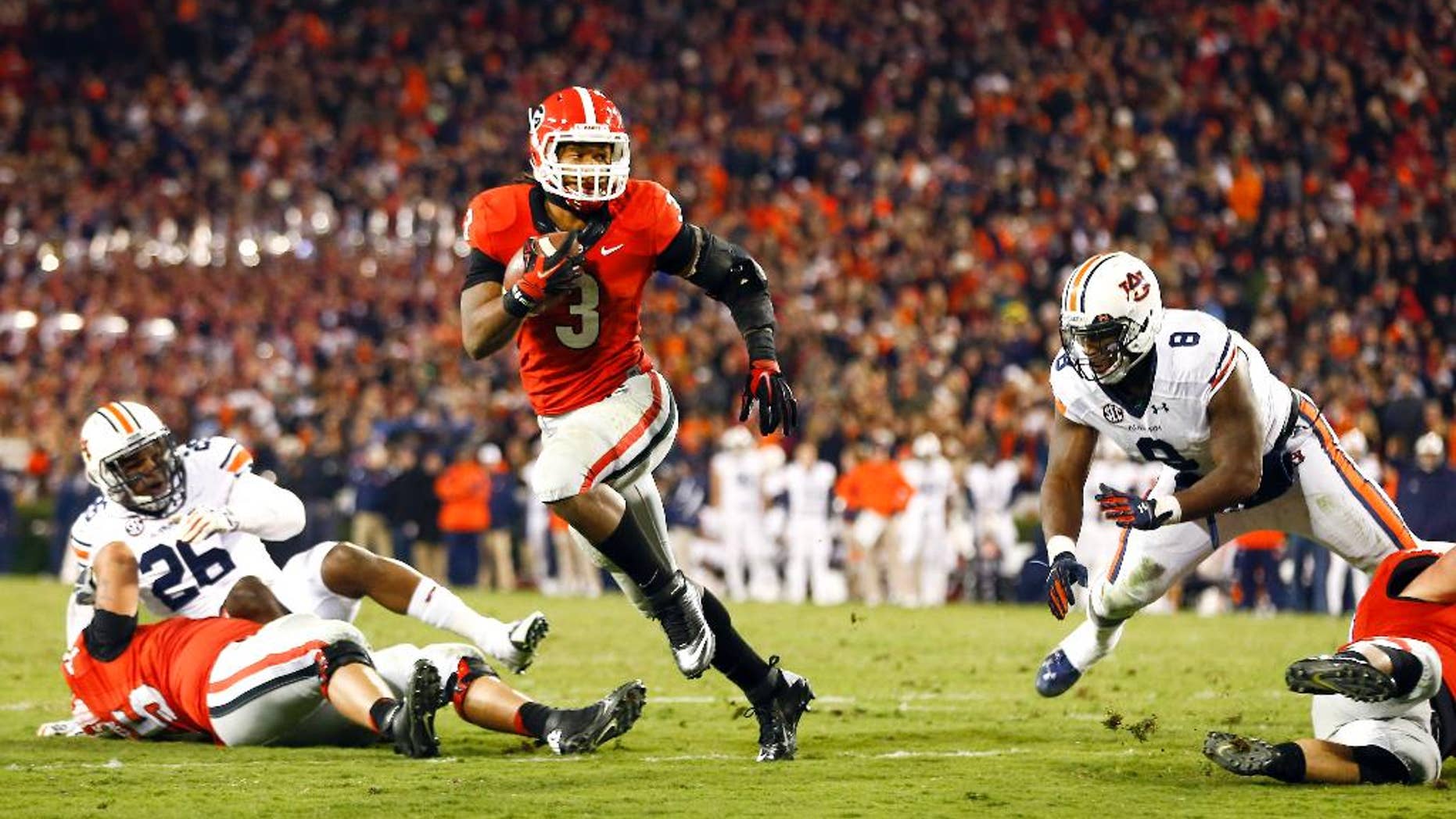 Auburn running back Cameron Artis-Payne (44) outruns Georgia defensive back Dominick Sanders (24) to score a touchdown in the first half of an NCAA college football game Saturday, Nov. 15, 2014, in Athens, Ga. (AP Photo/John Bazemore)