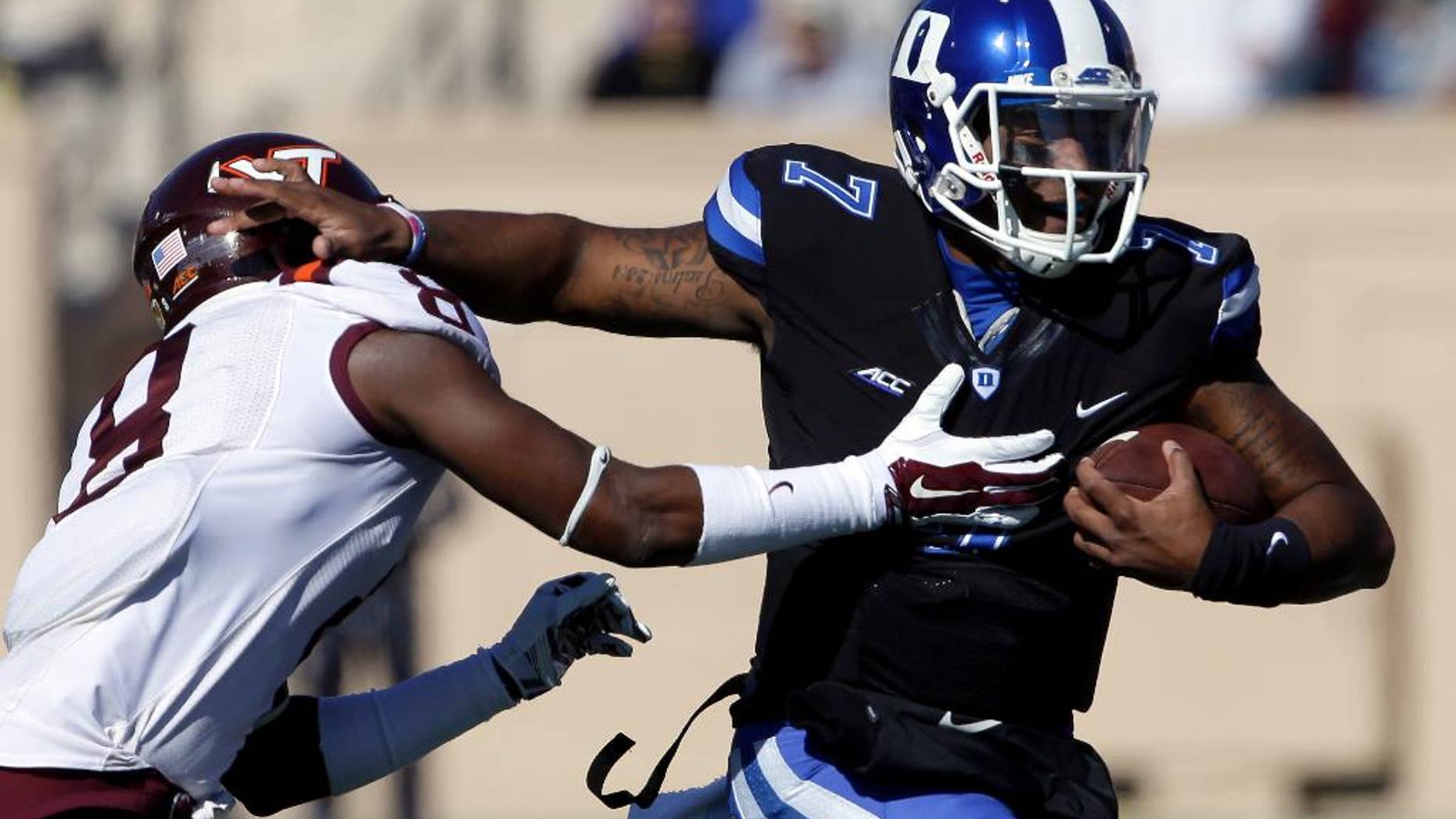 Duke quarterback Anthony Boone (7) runs the ball as Virginia Tech's Detrick Bonner (8) reaches to tackle during the first half of an NCAA college football game in Durham, N.C., Saturday, Nov. 15, 2014. (AP Photo/Gerry Broome)