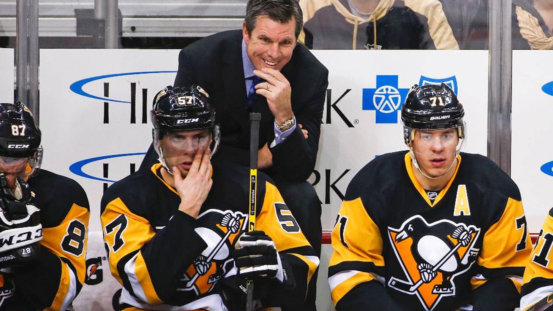 FILE - In this Jan. 2, 2016, file photo, Pittsburgh Penguins head coach Mike Sullivan stands behind David Perron (57), and Evgeni Malkin (71) during an NHL hockey game against the New York Islanders in Pittsburgh. The Penguins are on the cusp of a fourth Stanley Cup in large part to coach Sullivan’s uncanny ability to get the attention of a struggling player. (AP Photo/Gene J. Puskar, File)