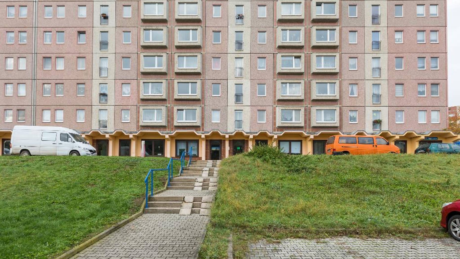 An apartment block photographed in Schmoelln, eastern Germany, Sunday Oct. 23, 2016. Officers were called to this building in Schmoelln on Friday afternoon Oct. 21, 2016 by the caregiver for a group of young migrants, who reported that a 17-year-old Somali boy was acting violently, police said. When they arrived, he was sitting on a fifth-floor window ledge. Police and fire officers tried to persuade the teenager not to jump, but he leapt and died shortly afterward of his injuries. Onlookers apparently shouted "Jump!" before the teenage migrant leapt from the apartment block in the eastern German town, suffering fatal injuries, the mayor said Saturday Oct. 22, 2016 . (Michael Reichel/dpa via AP)