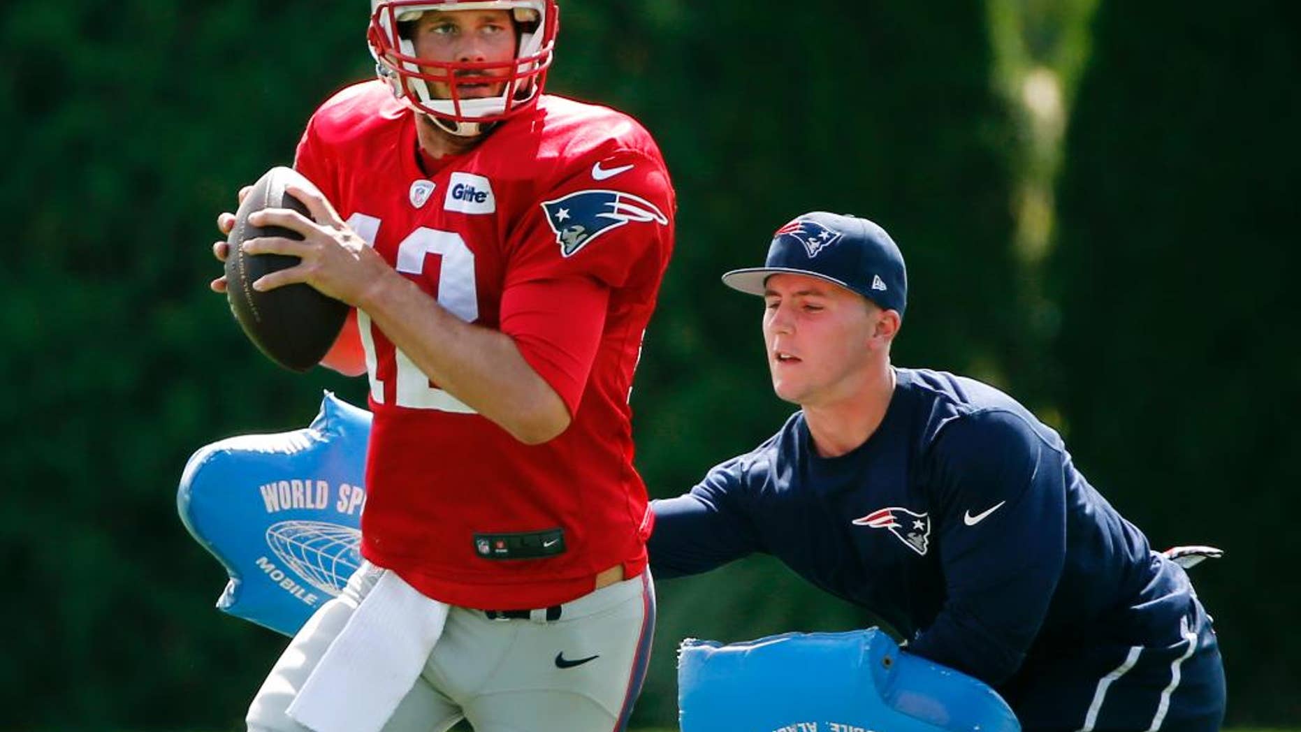 New England Patriots quarterback Tom Brady passes under pressure during a drill at team practice in Foxborough, Mass., Wednesday, Sept. 3, 2014. The Patriots are preparing for their opening NFL football game against the Miami Dolphins on Sunday in Miami. (AP Photo/Elise Amendola)