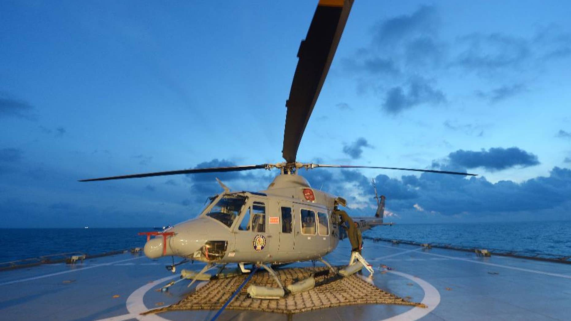Indonesian navy personnel check a helicopter as they prepare operations to lift the tail of AirAsia Flight 8501 in Java sea, Indonesia Friday, Jan. 9, 2015. Days after sonar detected apparent wreckage, an unmanned underwater vehicle showed the plane's tail, lying upside down and partially buried in the ocean floor. (AP Photo/Adek Berry, Pool)
