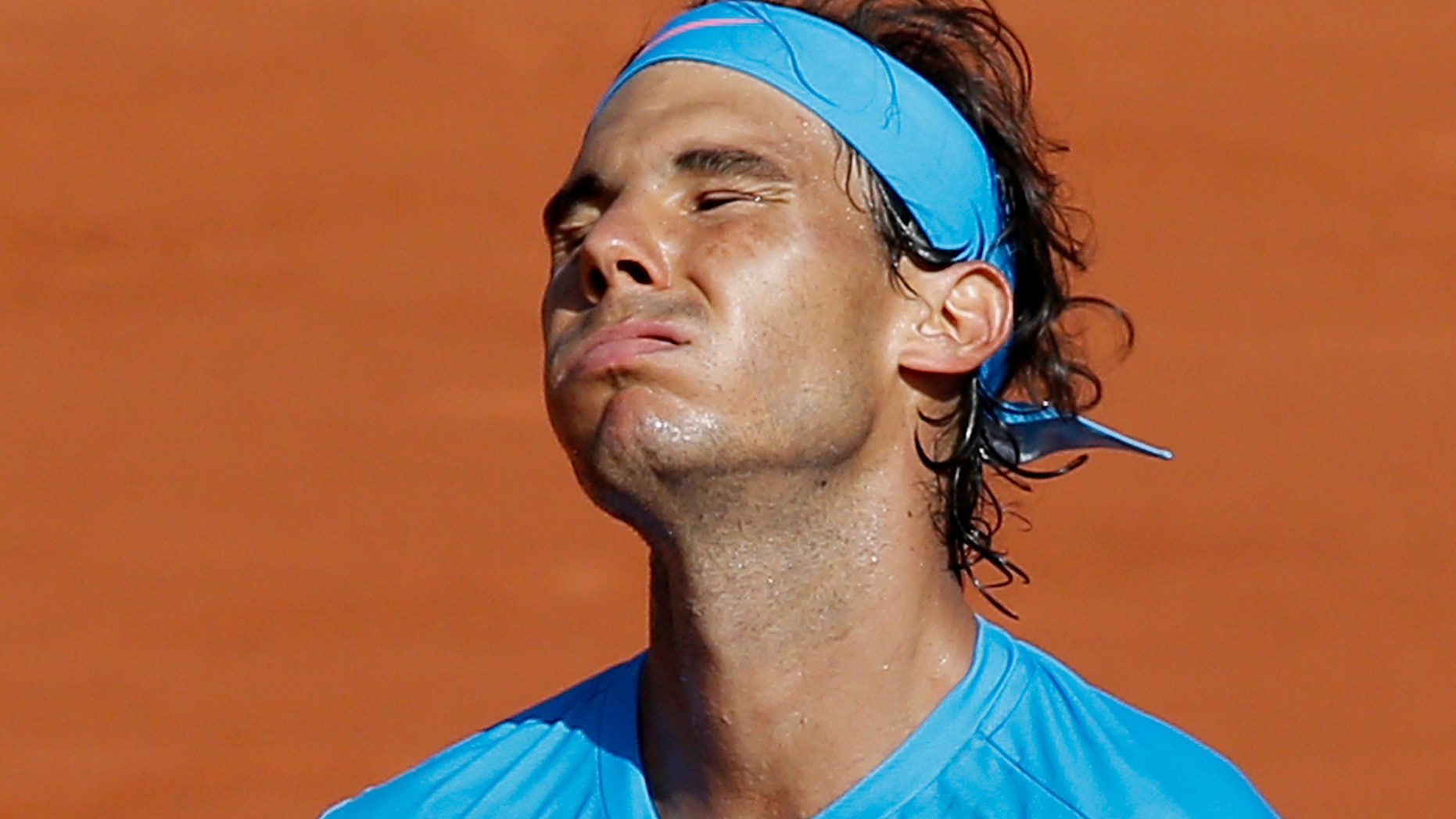 Spain's Rafael Nadal grimaces after missing a shot in the quarterfinal match of the French Open tennis tournament against Serbia's Novak Djokovic at the Roland Garros stadium, in Paris, France, Wednesday, June 3, 2015. (AP Photo/Christophe Ena)