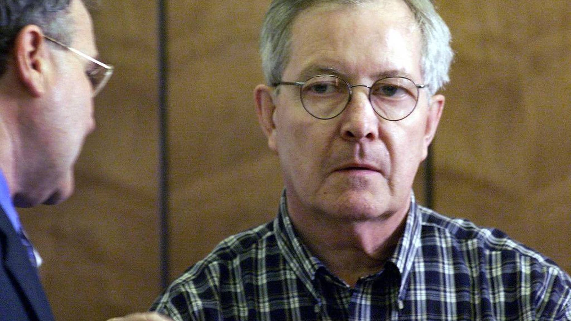 FILE - In this May 8, 2002, file photo, retired Catholic priest, the Rev. Ronald Paquin, right, talks with his Attorney, Kevin Reddington, left, during arraignment in District Court in Haverhill, Mass. Paquin was indicted Tuesday, Feb. 7, 2017, in Maine on 29 counts of sexual misconduct dating to the 1980s. Freed in 2015, Paquin was a central figure in the Boston archdiocese's sex abuse scandal. In 2002, he pleaded guilty to raping an altar boy. (Tom Landers/The Boston Globe via AP, Pool, File)