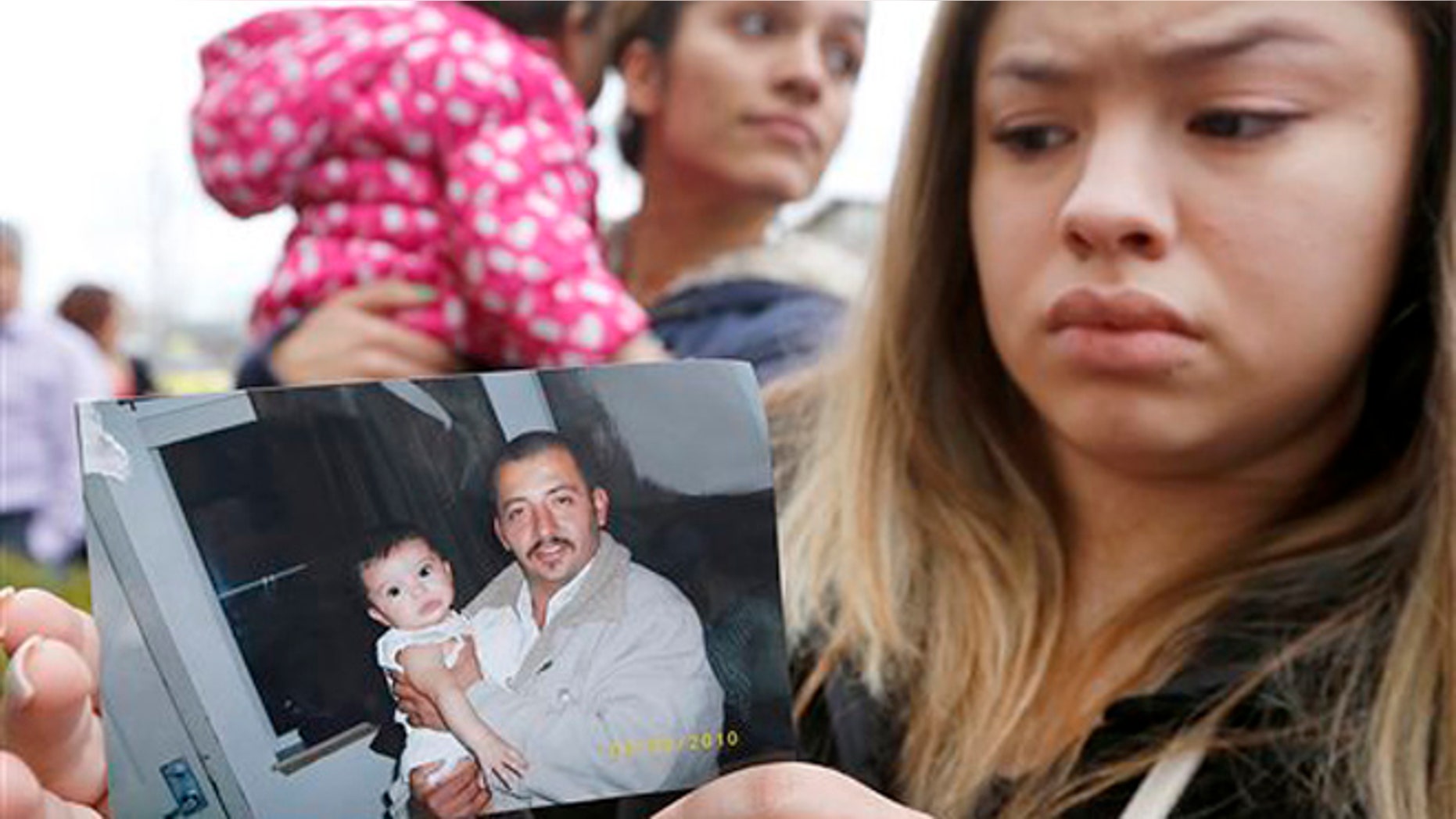 Erika Zambrano holds a 2010 photo of Antonio Zambrano-Montes, outside the city hall in Pasco, Wash.