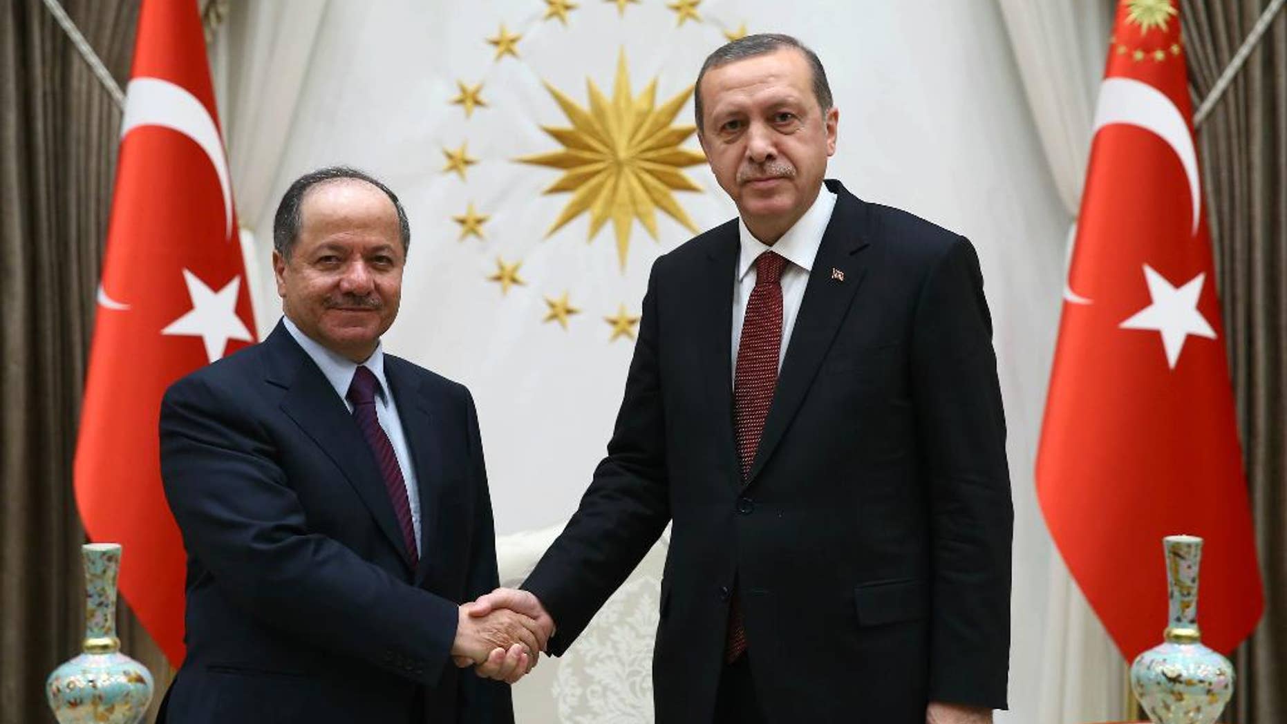 Turkish President Recep Tayyip Erdogan, right, and President of Iraq'a northern Kurdish region, Massoud Barzani, shake hands before a meeting in Ankara, Turkey, Wednesday, Dec. 9, 2015. Turkish Prime Minister Ahmet Davutoglu on Wednesday defended his country's deployment of additional forces to Iraq last week, saying it was an "act of solidarity" with Iraq's fight against the Islamic State group. Turkey has stationed troops at a base outside of the Iraqi city of Mosul since last year as part of a training mission coordinated with the Iraqi government in Baghdad. (AP Photo/Yasin Bulbul, Presidential Press Service, Pool )