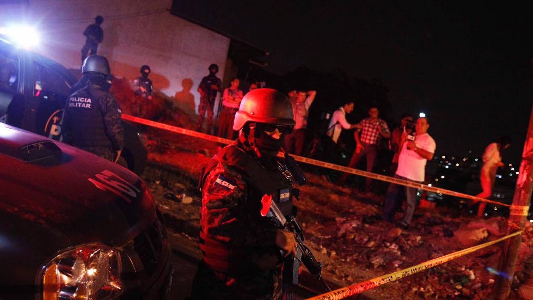 A military policeman stands guard after the old police headquarters building was raided by the Honduran Army and prosecution agents in Tegucigalpa, Honduras, late Monday, April 4, 2016. The agents were looking for evidence in the assassination of anti-drug prosecutor Julian Aristides Gonzalez in 2009. The Honduran government has vowed to suspend several top police officials amid mounting evidence they conspired to kill Gonzalez and two other prosecution employees. (AP Photo/Fernando Antonio)