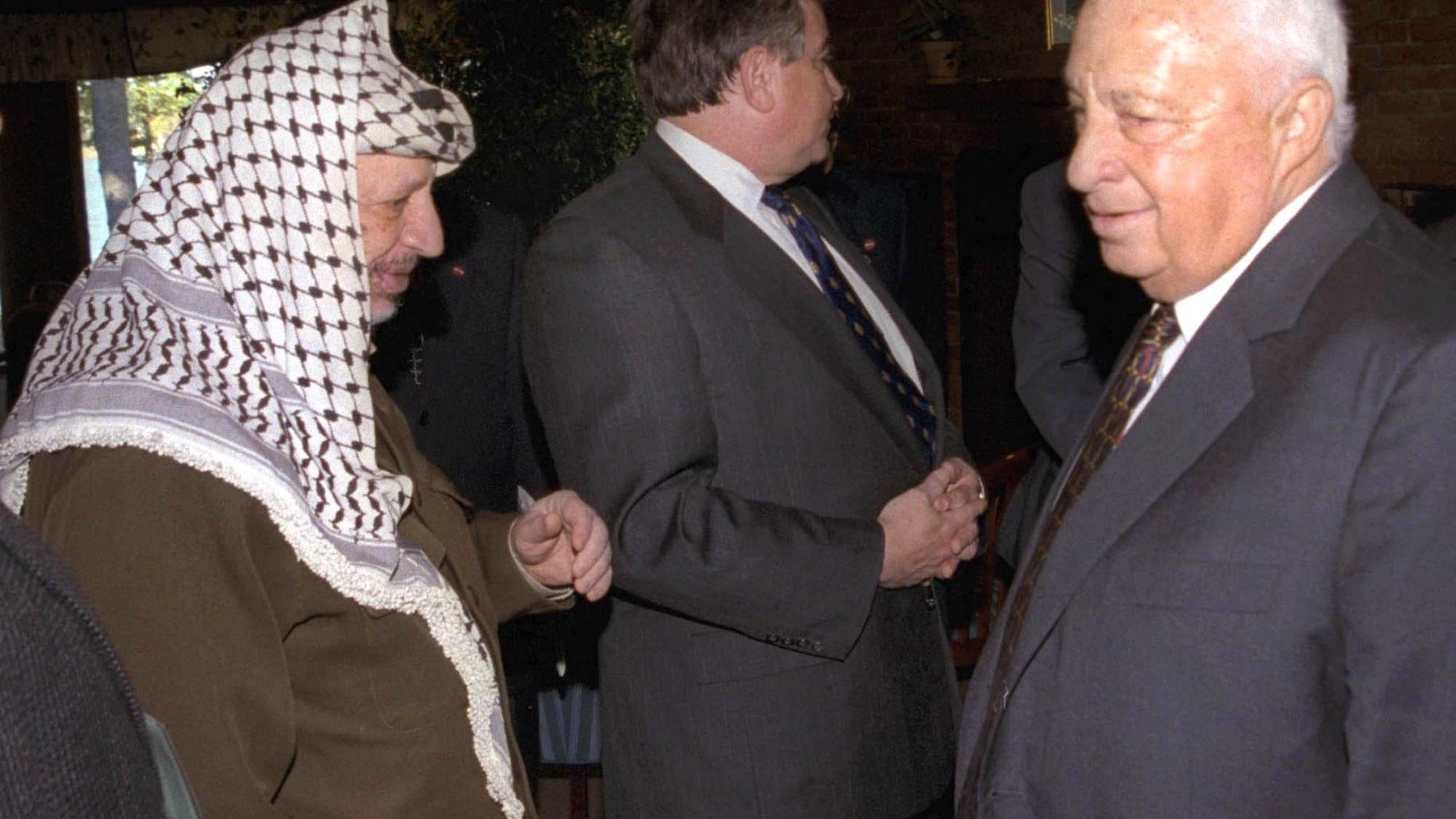 FILE - In this Oct. 21, 1998 file photo, Israeli Foreign Minister Ariel Sharon, right, stands near but does not look at, or shake hands with, Palestinian leader Yasser Arafat at Wye Plantation, Maryland. Before becoming a candidate, Sharon proudly boasted he had never shaken hands with Arafat, and called the Palestinian leader a "murderer and a liar" in an interview with the New Yorker magazine. Sharon, the hard-charging Israeli general and prime minister who was admired and hated for his battlefield exploits and ambitions to reshape the Middle East, died Saturday, Jan. 11, 2014. The 85-year-old Sharon had been in a coma since a debilitating stroke eight years ago. (AP Photo/Israel Government Press Office, File)