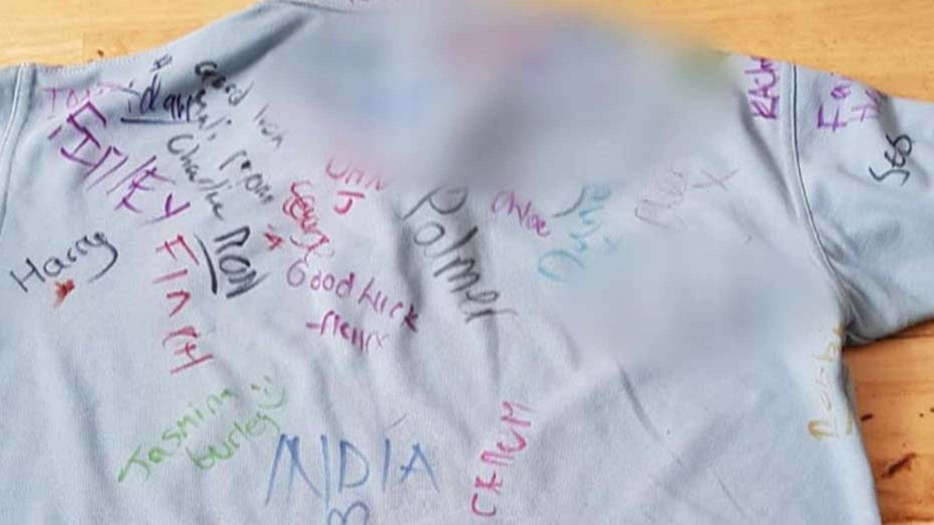 A British teenager was "distraught" after learning his classmates had written racist slurs on his t-shirt, his mother said.