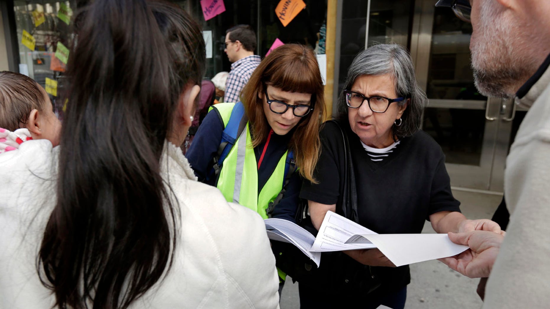 In this Tuesday, April 11, 2017, photo, Sarah Gozalo, center left, and Marisa Lohse, center right, of the New Sanctuary Coalition of NYC, review the Application for Asylum of Joselin Marroquin-Torres, left, before her appearance in federal immigration court in New York.