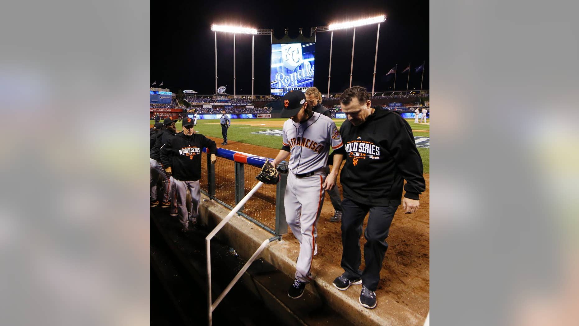 San Francisco Giants pitcher Tim Lincecum is helped into the team's dugout during the eighth inning of Game 2 of baseball's World Series Wednesday, Oct. 22, 2014, in Kansas City, Mo. Kansas City Royals defeated the Giants 7-2 to tie the series at 1-1 games. (AP Photo/Matt Slocum)