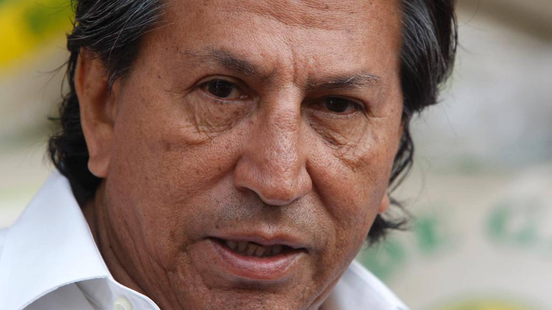 FILE - In this March 17, 2011 file photo, Peru's former President Alejandro Toledo campaigns for reelection at the Santa Anita wholesale market in Lima, Peru. Peruvian authorities said they searched Toledo's house on Saturday, Feb. 4, 2017 in a case involving alleged bribes from a construction firm under investigation in a major corruption probe in Brazil. Toledo currently is in Paris and denied the charges by telephone to Peruvian media. (AP Photo/Karel Navarro, File)