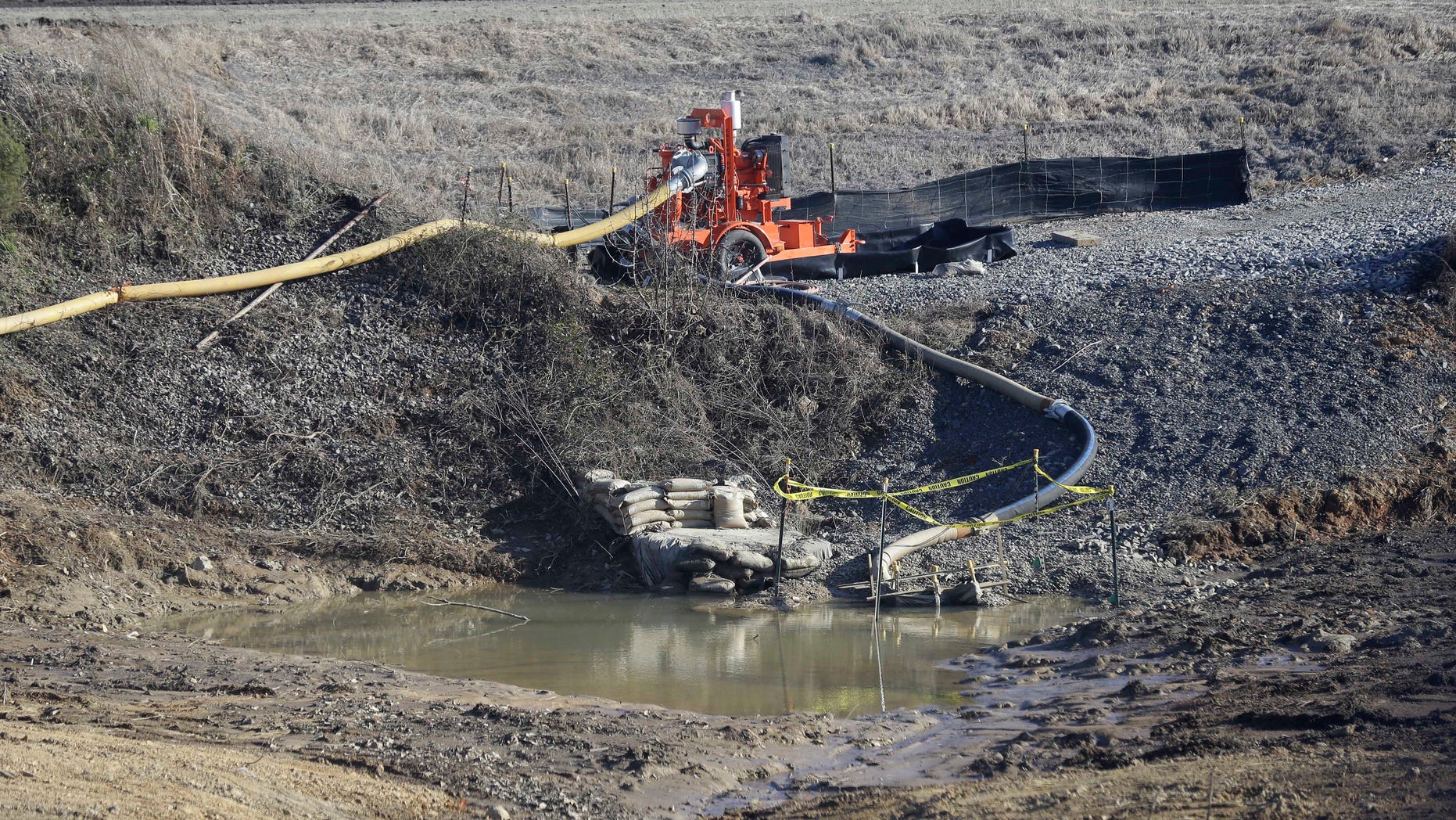 FILE - In this Jan. 14, 2016 file photo, a drainage pipe that was the original culprit of the coal ash spill is seen at the Dan River Steam Station in Eden, N.C. North Carolina's top public health official acted unethically and possibly illegally by telling residents living near Duke Energy coal ash pits that their well water is safe to drink when it's contaminated with a chemical known to cause cancer, a state toxicologist said in sworn testimony. (AP Photo/Gerry Broome, File)