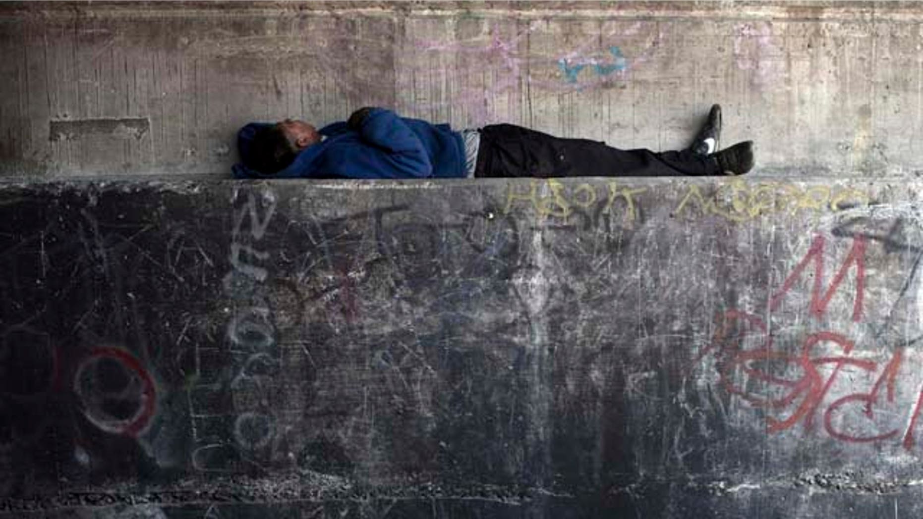 In this photo taken June 22, 2011, a homeless men tries to rest inside a Tijuana River canal, in Tijuana, Mexico. During the day, deportees who find themselves in Tijuana look for work and flee Mexican police, who will jail them for not having papers, just like in the U.S. At night they take refuge in the canals, beneath bridges or in shacks, among drug addicts and people with mental health problems; a few feet from the rusty barrier that separates the country of their birth from the country where they worked years for a better life. (AP Photo/Alejandro Cossio)