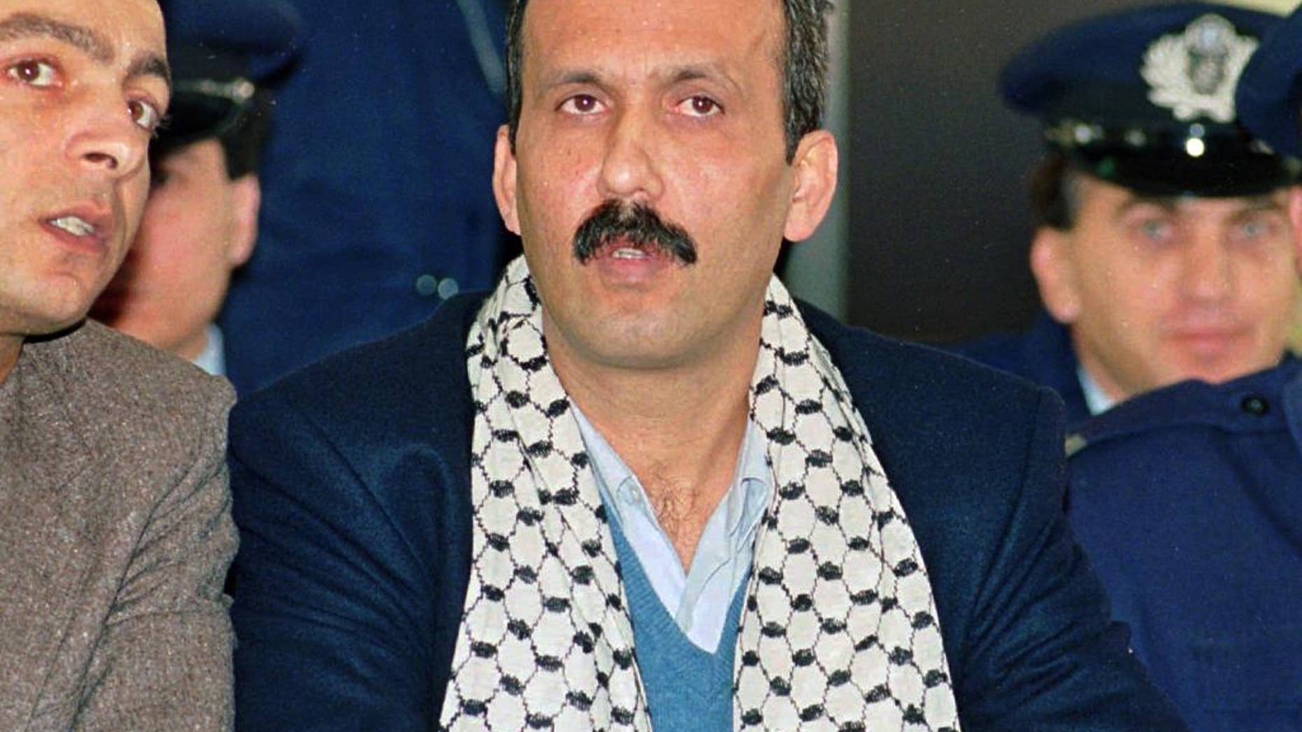 FILE - In this Dec. 12, 1991 file photo Mohammed Rashed, center, convicted of the 1982 PanAm jetliner bombing, listens to his interpreter, left, during his appeals court hearing in Athens, Greece. Rashed, the Jordanian-born Palestinian who’s been in immigration custody since he finished a prison sentence for putting a bomb on a plane in 1982 is expected to appear in a Buffalo courtroom in his bid for release. Rashed has been held at a facility outside Buffalo while the government has explored options to deport him. A federal court hearing is scheduled for Tuesday, June 7, 2016. (AP Photo/Aris Saris, File)