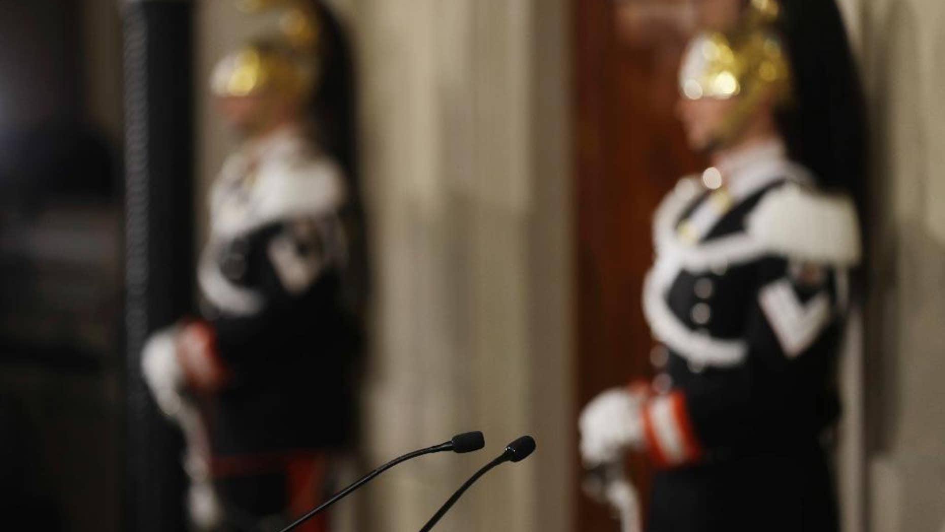 Courassier presidential guards stand next the studio of Italian president Sergio Mattarella, with in foreground the microphones from where politicians talk to the media at the Quirinal Palace in Rome, Thursday, Dec. 8, 2016. President Mattarella starts today a three-day round of talks with political leaders to try and form a new government. (AP Photo/Gregorio Borgia)