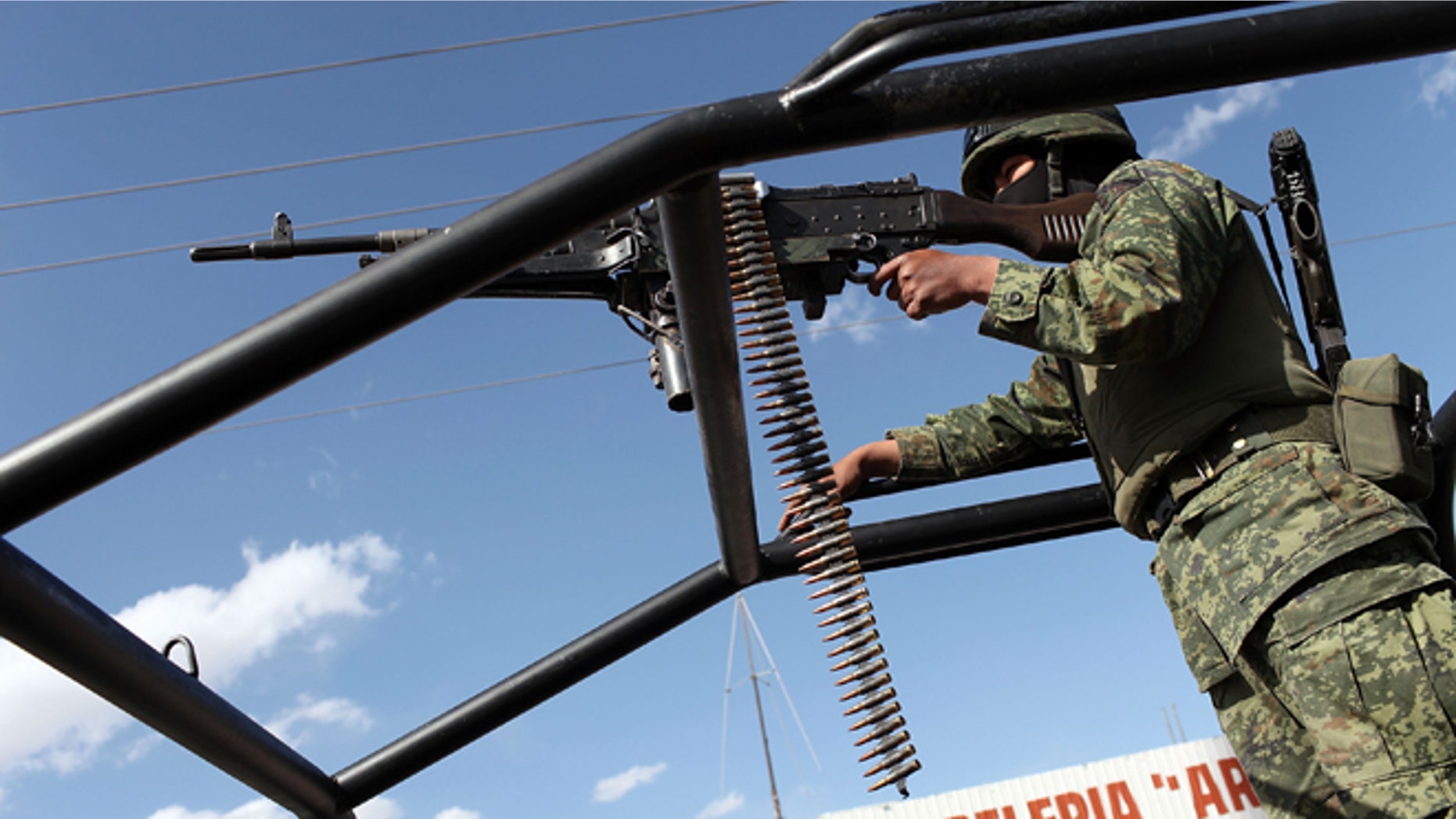 JUAREZ, MEXICO - MARCH 19: A member of the Mexican Army keeps guard near the site of a recent murder on March 19, 2010 in Juarez, Mexico. The border city of Juarez has been racked by violent drug-related crime, making it among the most dangerous cities in the world. As competing drug cartels fight over lucrative drug corridors along the U.S. border, the murder rate in Juarez has risen to 173 slayings for every 100,000 residents. President Felipe Calderon in 2009 disbanded the corrupt local police force and sent 10,000 soldiers to Juarez, but the violence has raged on. With a population of 1.3 million in Juarez, 2,600 died in drug-related violence last year and 500 so far this year, including two Americans who worked for the U.S. Consulate last weekend as they returned from a childrens party. (Photo by Spencer Platt/Getty Images)