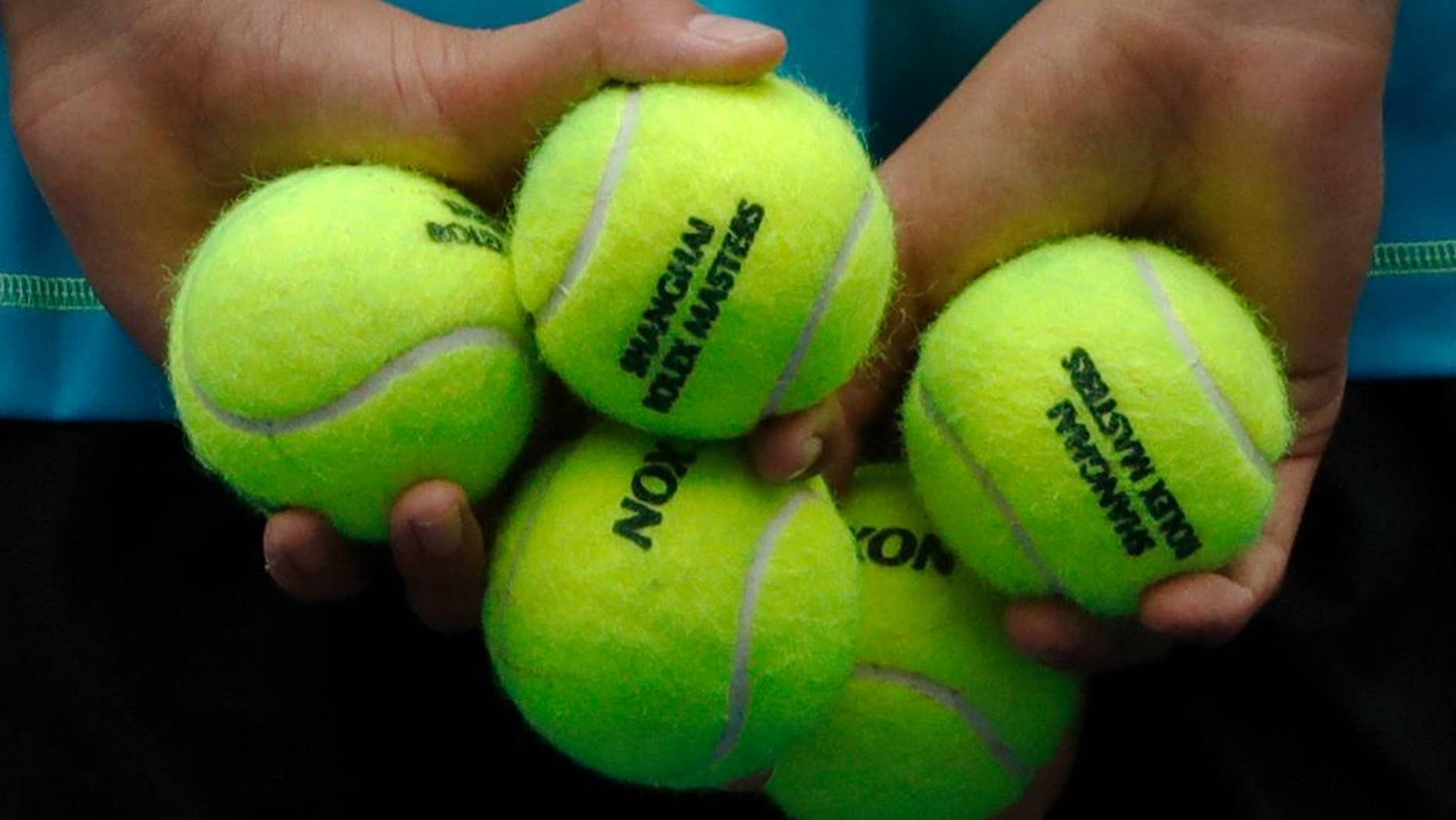 A ball boy holds tennis balls during the men's singles match between Stan Wawrinka of Switzerland and Kyle Edmund of Britain in the Shanghai Masters tennis tournament at Qizhong Forest Sports City Tennis Center in Shanghai, China, Wednesday, Oct. 12, 2016. (AP Photo/Andy Wong)