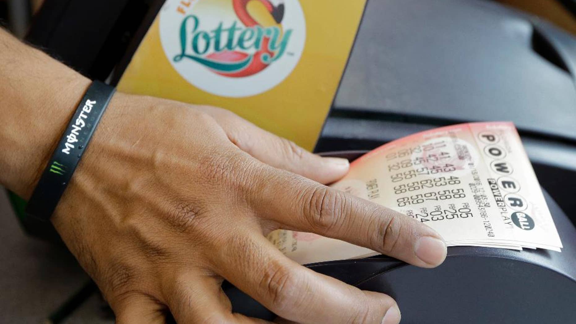 FILE - In this Jan. 13, 2016 file photo, a clerk at a convenience store pulls Powerball tickets from a printer for a customer in Tampa, Fla. The Powerball jackpot for the Wednesday, July 27, 2016, drawing has soared to over $420 million thanks to nearly three months without a winner of the big prize. (AP Photo/Chris O'Meara, File)