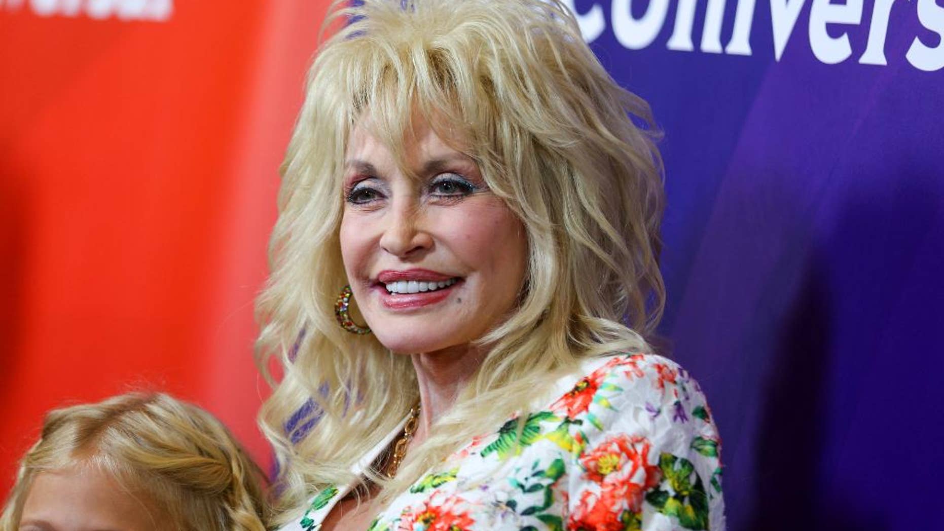FILE - In this Aug. 13, 2015 file photo, Dolly Parton arrives at the NBCUniversal Summer TCA Tour in Beverly Hills, Calif. Parton and pop star Katy Perry will sing together at the 51st annual Academy of Country Music Awards, where Parton will be receiving a special award for her recent television movie about her childhood. The ACM Awards will air live on April 3 from the MGM Grand Garden Arena in Las Vegas on CBS. (Photo by Rich Fury/Invision/AP, File)