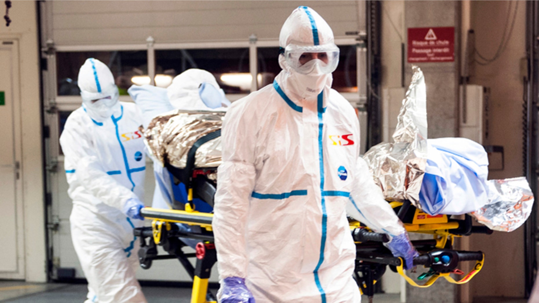 In this photo provided by the Geneva University Hospital (HUG), Cuban doctor Felix Baez Sarria, who contracted Ebola in Sierra Leone, arrives on a gurney at the Geneva University Hospital in Geneva, Switzerland, Friday, Nov. 21, 2014. Baez, a member of the 165-person medical team Cuba sent to Sierra Leone to help with the Ebola outbreak, caught the disease when he rushed to help a patient who was falling over. (AP Photo/Julien Gregorio, Geneva University Hospital) MANDATORY CREDIT, NO ARCHIVE