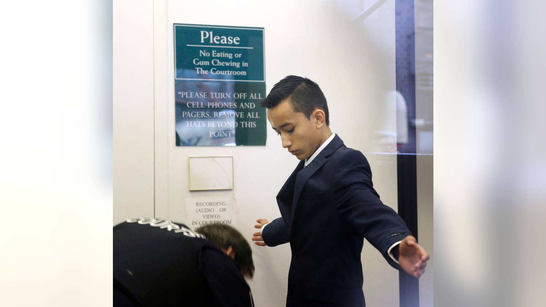 FILE- In this April 2, 2014 file photo, Justin Casquejo passes through security at a courthouse in New York. The teenage daredevil who climbed the World Trade Center's centerpiece tower in 2014 has surrendered to police on Friday, Dec. 2, 2016, after videos posted on social media showed him dangling from other Manhattan skyscrapers. (AP Photo/Seth Wenig, File)