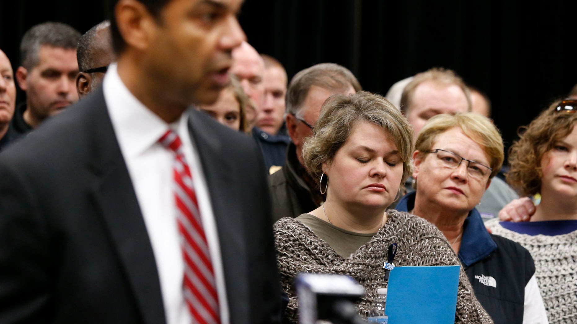 Beth Stauffer, center, reacts on Sunday, Dec. 29, 2013, as FBI Special Agent in Charge Danile McMullen announces they believe the bank robber who killed her husband, Sgt. Gale Stuaffer on Monday, was killed attempting another bank robbery in Phoniex, Ariz., on Saturday in Tupelo, Miss. (AP Photo/Northeast Mississippi Daily Journal, Thomas Wells) MANDATORY CREDIT