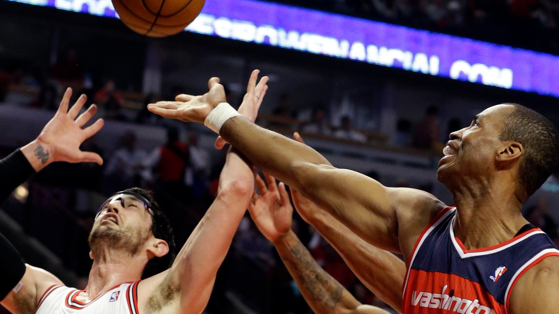 FILE - In this April 17, 2013 file photo, Washington Wizards center Jason Collins, right, battles for a rebound against Chicago Bulls guard Kirk Hinrich during the first half of an NBA basketball game in Chicago. Jason Collins has become the first male professional athlete in the major four American sports leagues to come out as gay. Collins wrote a first-person account posted Monday on Sports Illustrated's website. The 34-year-old Collins has played for six NBA teams in 12 seasons. He finished this past season with the Washington Wizards and is now a free agent. He says he wants to continue playing. (AP Photo/Nam Y. Huh, File)