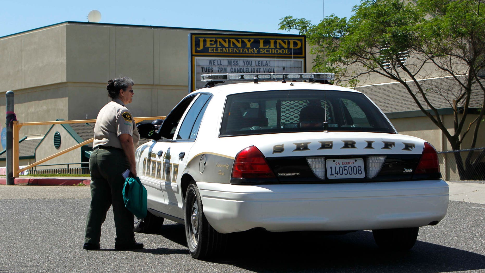 FILE - In this April 29, 2013 file photo, Calaveras County Sheriff's deputies and volunteers stand watch at Jenny Lind Elementary School, after the murder of one it's students over the weekend, in Valley Springs, Calif. Authorities on Saturday, May 11, 2013 arrested the 12-year-old brother of an 8-year-old girl who was mysteriously stabbed at her home in a quiet Northern California community last month. (AP Photo/Rich Pedroncelli, File)