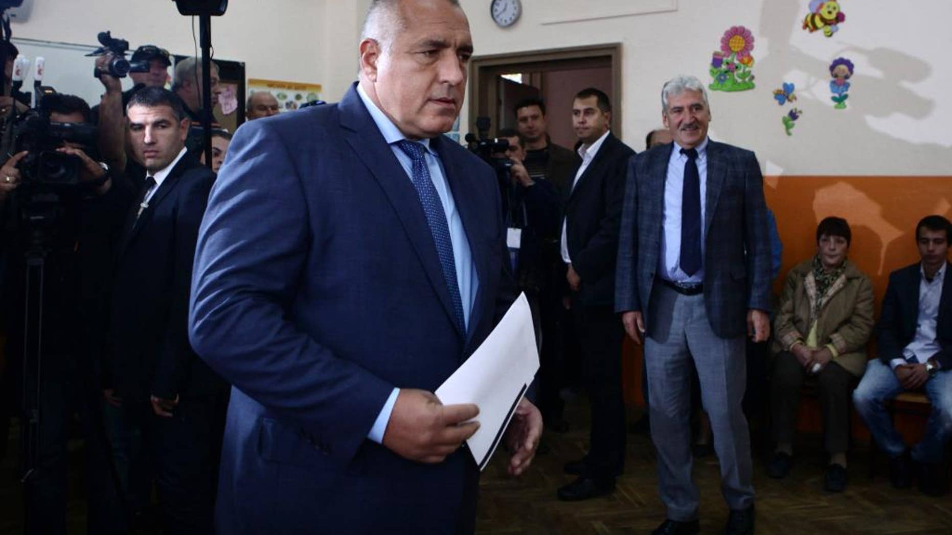 Boyko Borissov, former Bulgarian Prime Minister and leader of centre-right GERB party, holds his voting papers in Sofia, Sunday, Oct. 5, 2014. Opinion surveys predict the biggest vote winner will be center-right GERB party led by a former prime minister, Borisov, who says he would only continue building Bulgaria’s part of the South Stream pipeline if the EU approved. Bulgarians are voting in a parliamentary election hoping a new government will end the political stalemate, revive the economy, solve a severe banking crisis, and find ways to ease Moscow's grip on the country's energy supplies. (AP Photo/STR)