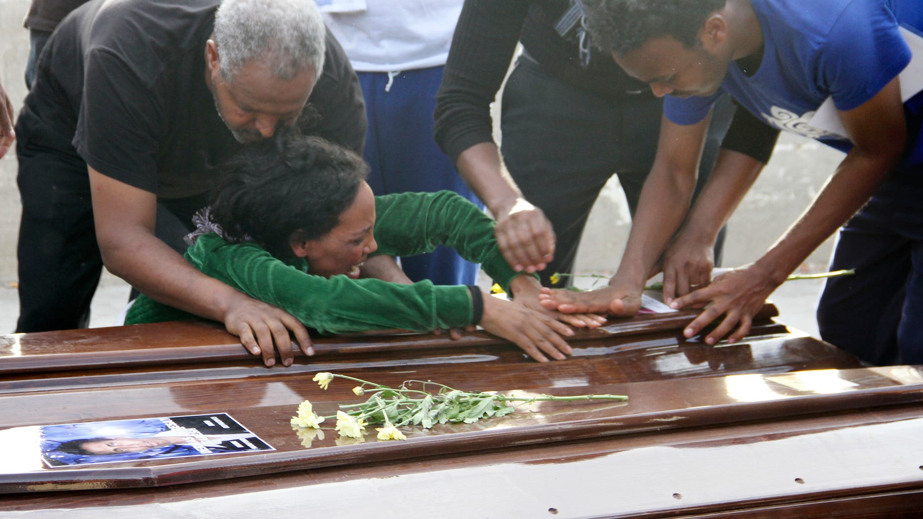 A survivor cries on the casket of her sister who died when their boat capsized off in the Canal of Sicily before it is embarked on a Italian Navy ship at the Lampedusa island harbor, Saturday, Oct. 12, 2013. A fishing boat packed with 500 African migrants capsized on Thursday Oct. 3, 2013 off the shores of the island of Lampedusa, causing more than 300 dead. The enormous scale of the tragedy, which could become the largest death toll in a migrant shipwreck in the Mediterranean on record, has created momentum for a comprehensive European Union immigration policy to cope with the tens of thousands fleeing misery and strife in Africa and the Middle East. (AP Photo/Mauro Buccarello)