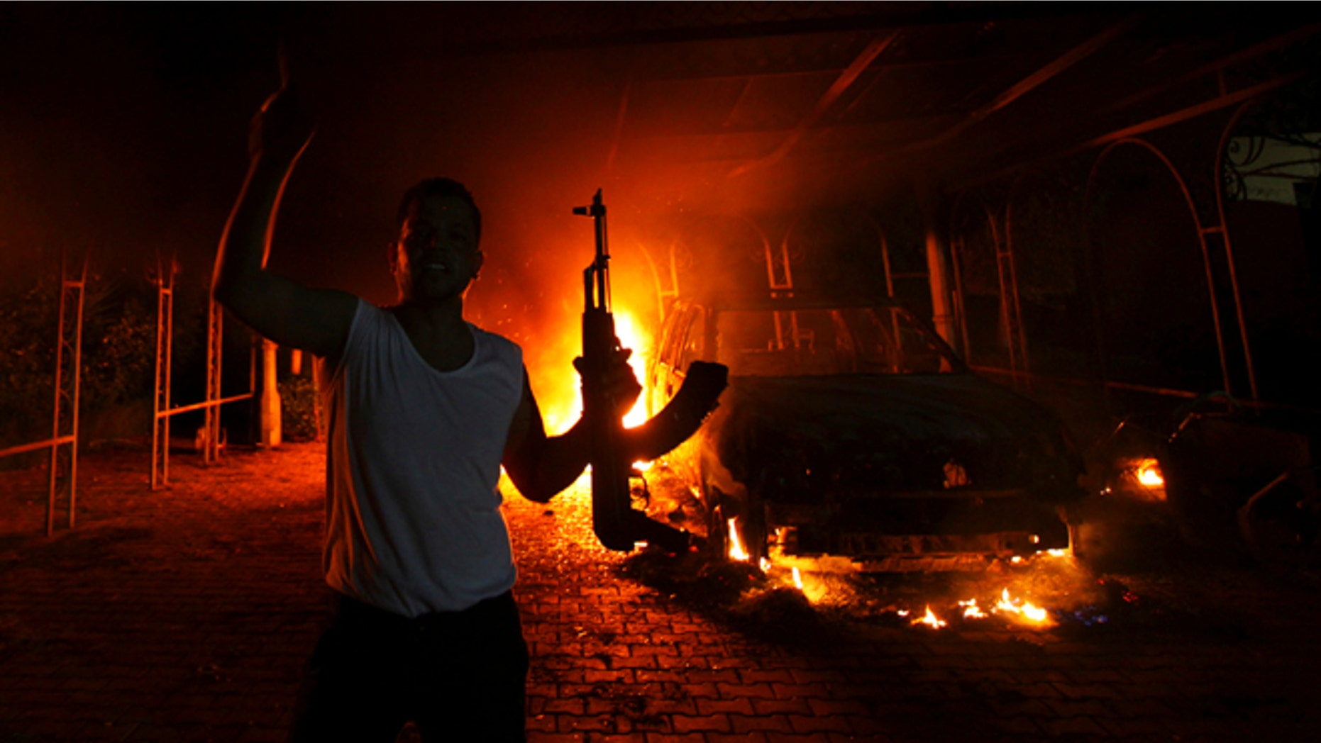 Sept. 11, 2012: A protester reacts as the U.S. Consulate in Benghazi is seen in flames during a terrorist attack which claimed the lives of four Americans.