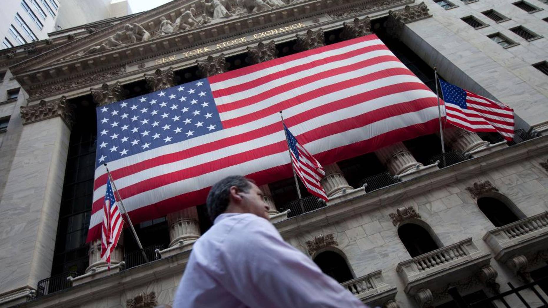 FILE - In this Monday, Aug. 8, 2011 file photo, a pedestrian walks past the New York Stock Exchange in New York. A weak batch of earnings reports is sending the stock market slightly lower in early trading Thursday, April 30, 2015. (AP Photo/Jin Lee, File)