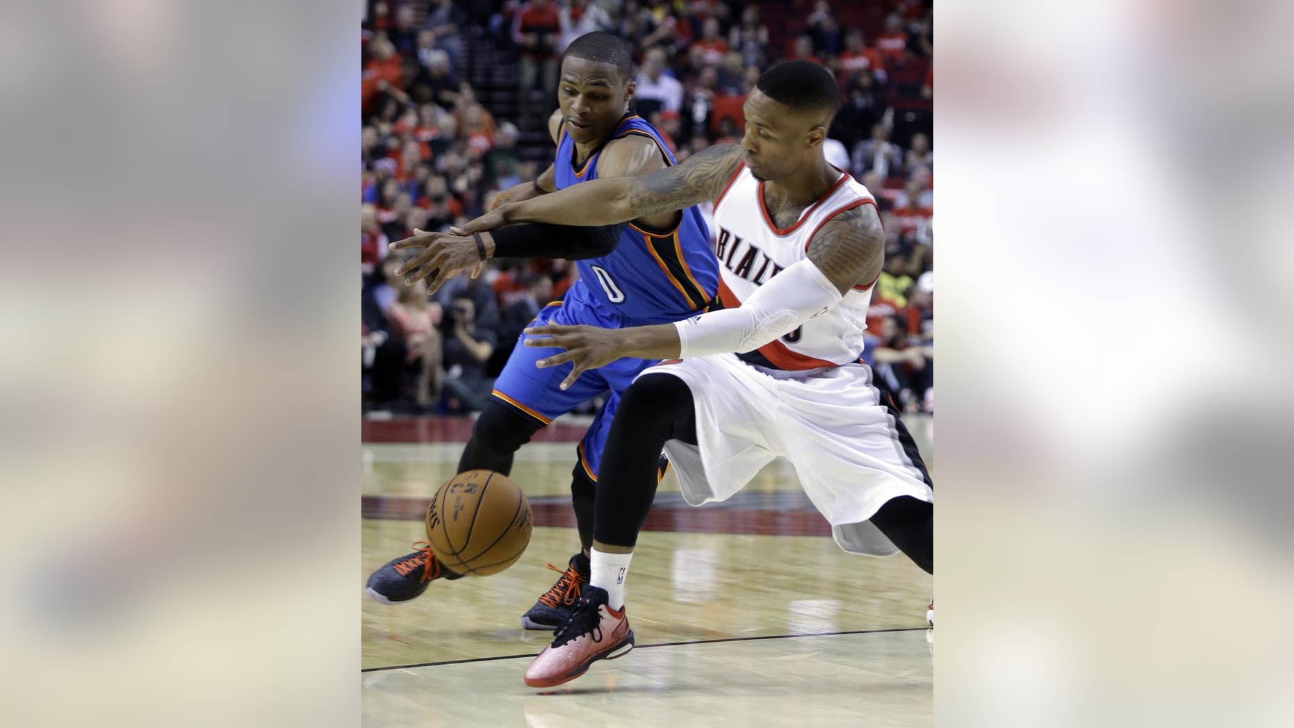 Oklahoma City Thunder guard Russell Westbrook, left, battles for the ball with Portland Trail Blazers guard Damian Lillard during the second half of an NBA basketball game in Portland, Ore., Wednesday, Oct. 29, 2014. Westbrook score 38 points as the Trail Blazers won 106-89.(AP Photo/Don Ryan)