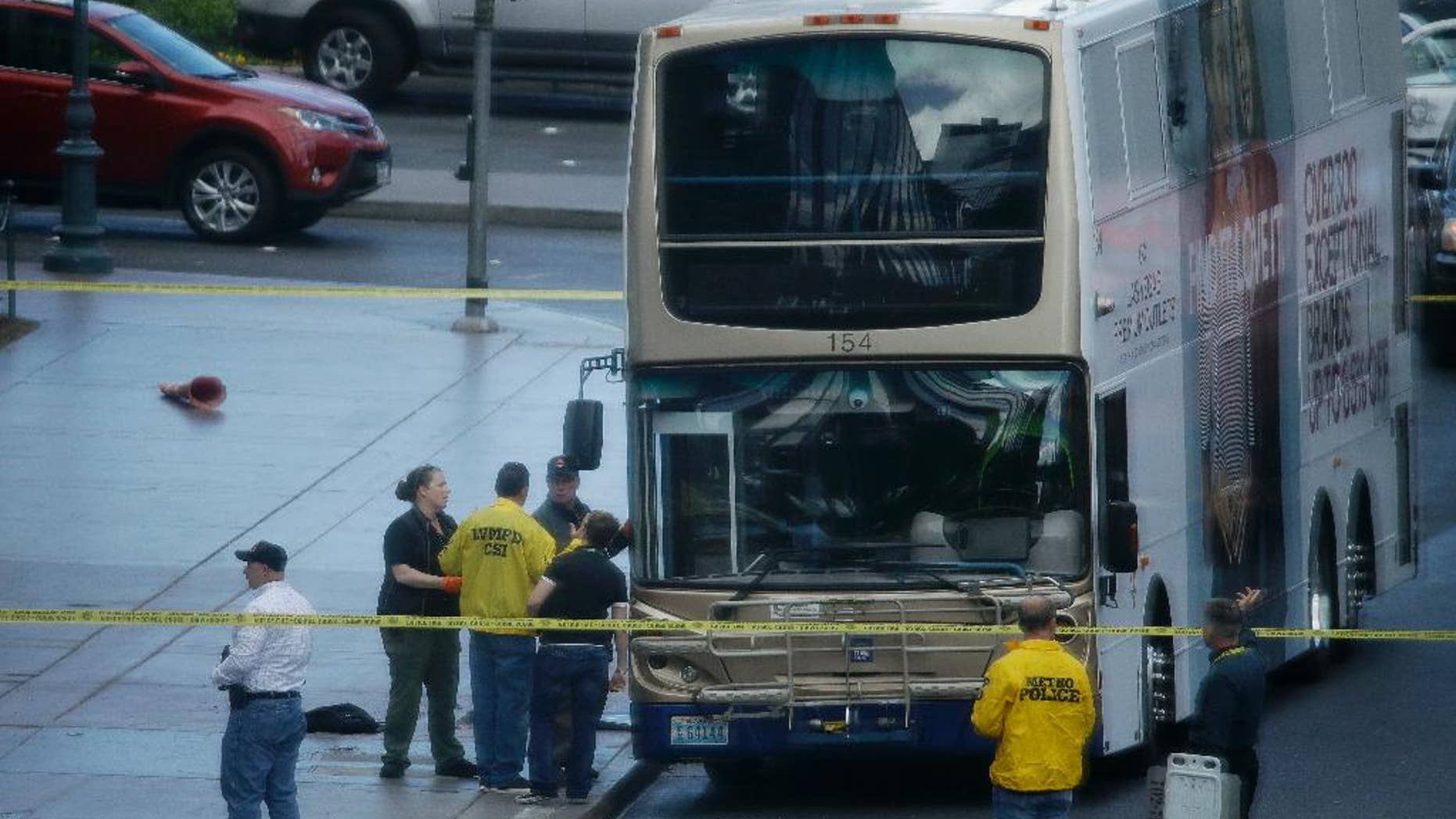 Las Vegas police investigate the scene of a stand-off in a bus along Las Vegas Boulevard, Saturday, March 25, 2017, in Las Vegas. Las Vegas police said the gunman in a fatal shooting on the Strip who barricaded himself inside a public bus has surrendered peacefully after shutting down the busy tourism corridor for hours. (AP Photo/John Locher)