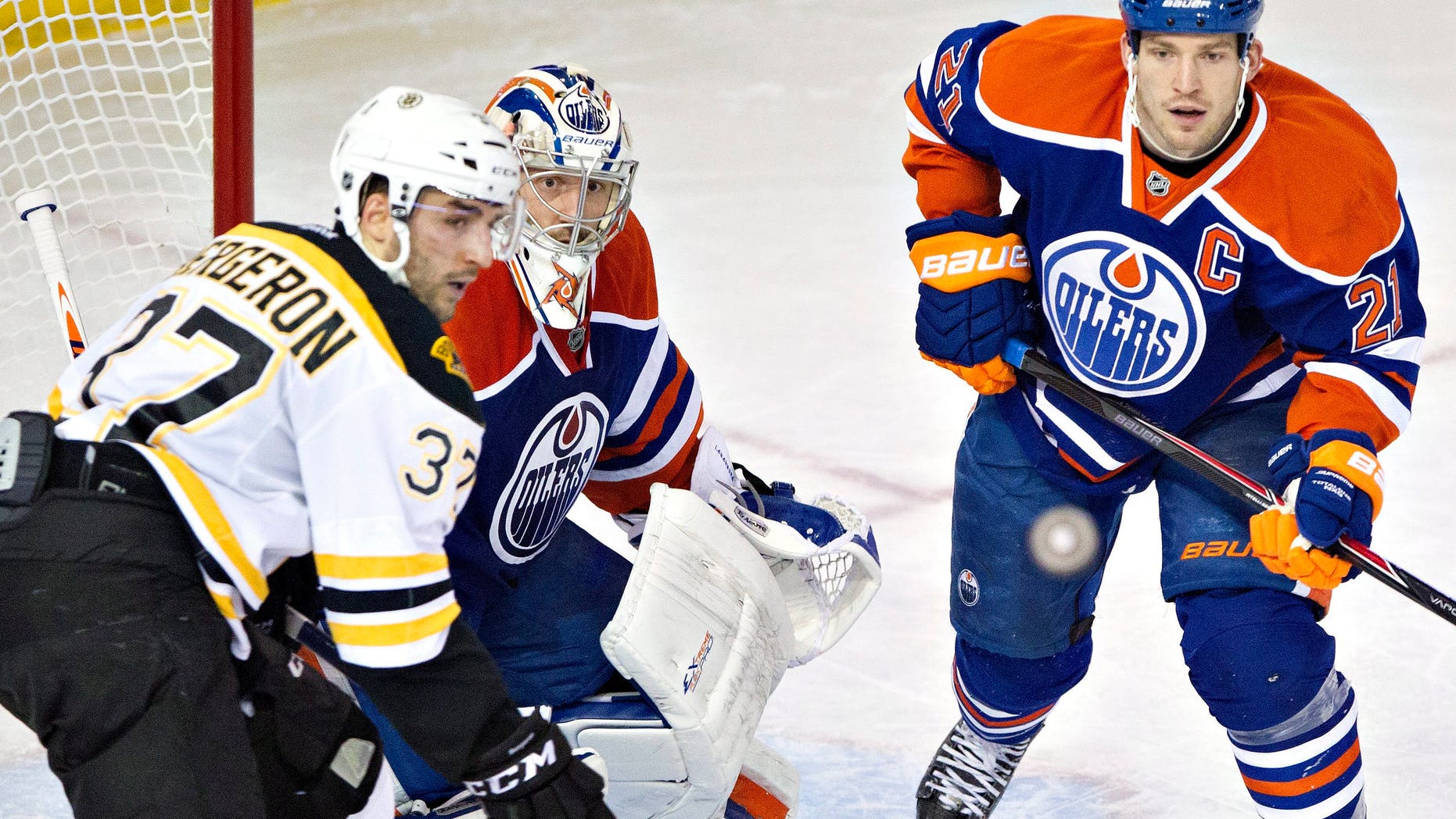 Boston Bruins' Patrice Bergeron (37), Edmonton Oilers goalie Jason LaBarbera (1) and Oilers' Andrew Ference (21) look for the rebound during the second period of an NHL hockey game, Thursday, Dec. 12, 2013 in Edmonton, Alberta. (AP Photo/The Canadian Press, Jason Franson)
